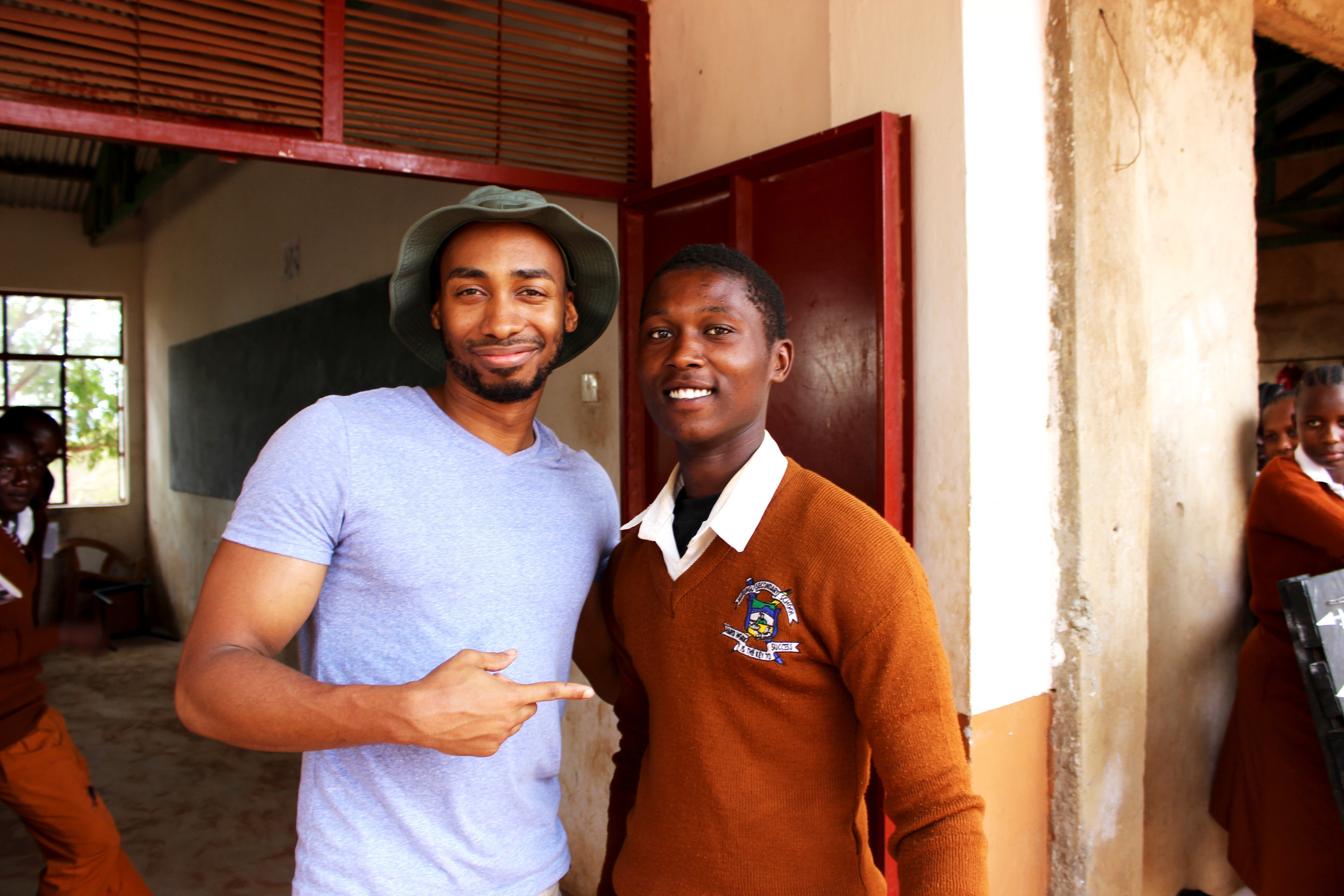 Prince Ea poses with a student of Marungu Secondary School near the Wildlife Works Kasigau Corridor REDD Project in Kenya. Prince Ea and the aspiring rapper each performed for the local classrooms.