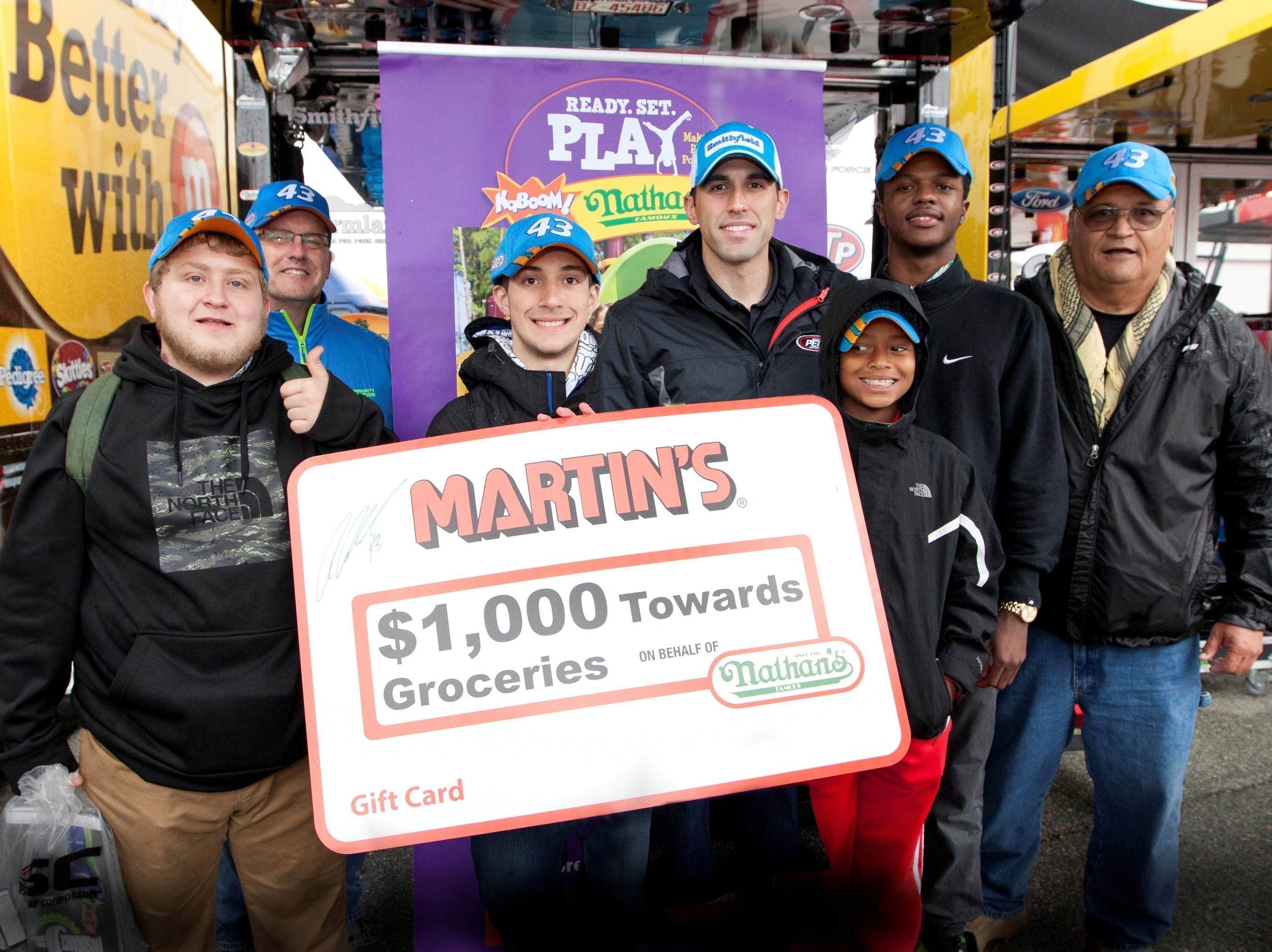 NASCAR driver Aric Almirola presented representatives from United Methodist Family Services with a MARTIN's Food Markets gift card worth $1,000 towards the purchase of groceries, courtesy of Nathan's Famous.