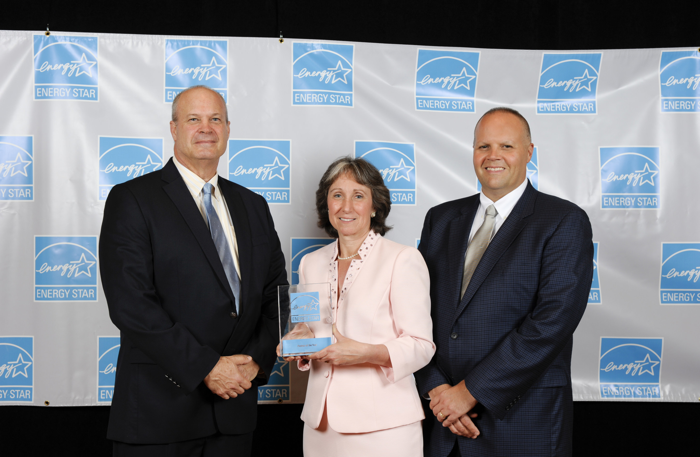 Jean Lupinacci, Acting Director of the Climate Protection Partnerships Division, center, of the U.S. Environmental Protection Agency presents Dave Bell, VP of Building Science, left, and Robert Buck, President, right, of TopBuild with a 2015 ENERGY STAR Partner of the Year - Home Energy Rater Award.