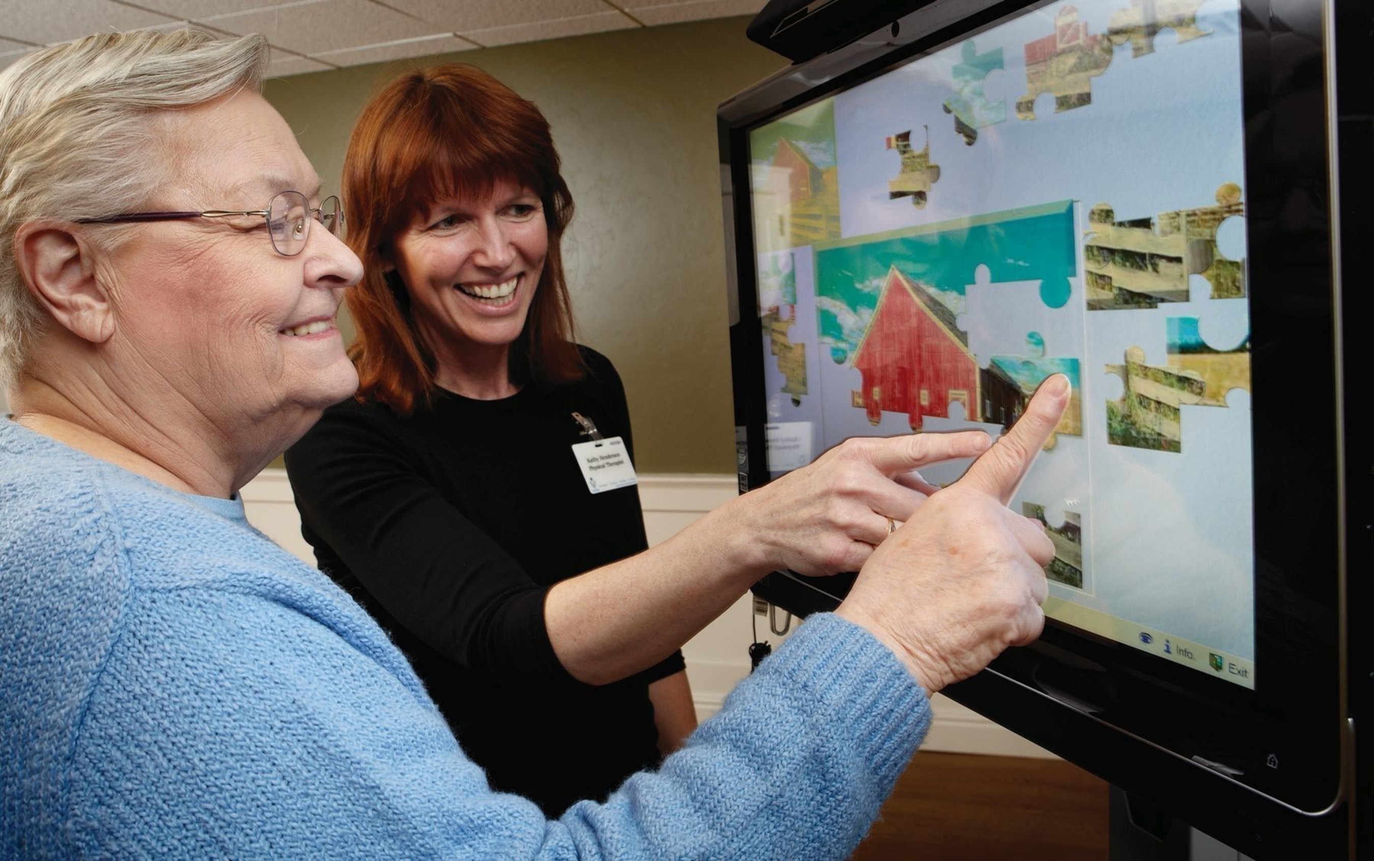 A caregiver uses iN2L technology to foster interaction with a resident. Research shows this technology can revive engagement and strengthen connections with family members.