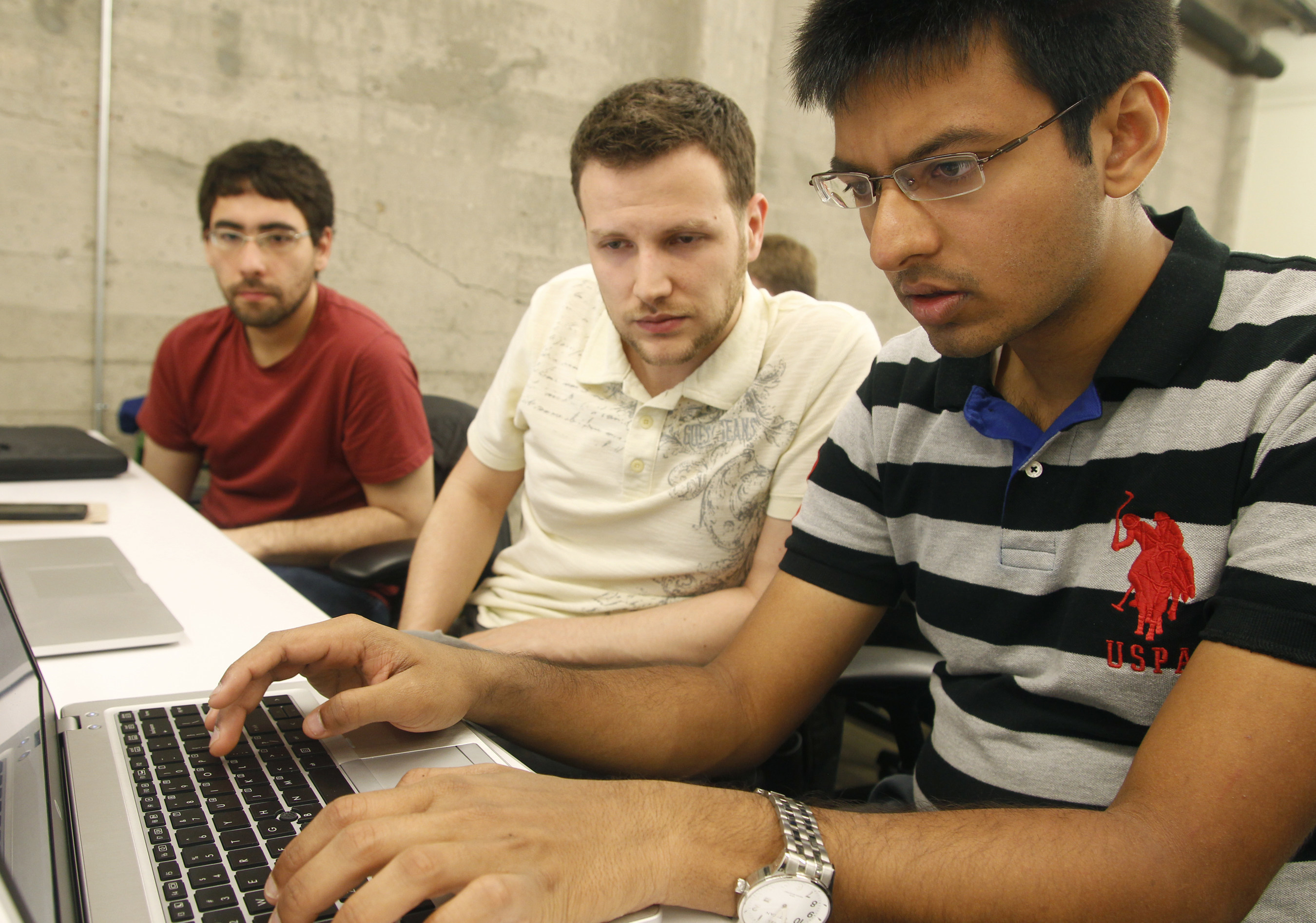 Shiva Gopalan, an engineering student at Texas A&M University, confers with IBM developers Henrique Copelli Zambon and Luiz Aoqui, during an IBM hosted Spark Hackathon at Galvanize, a tech hub in San Francisco.