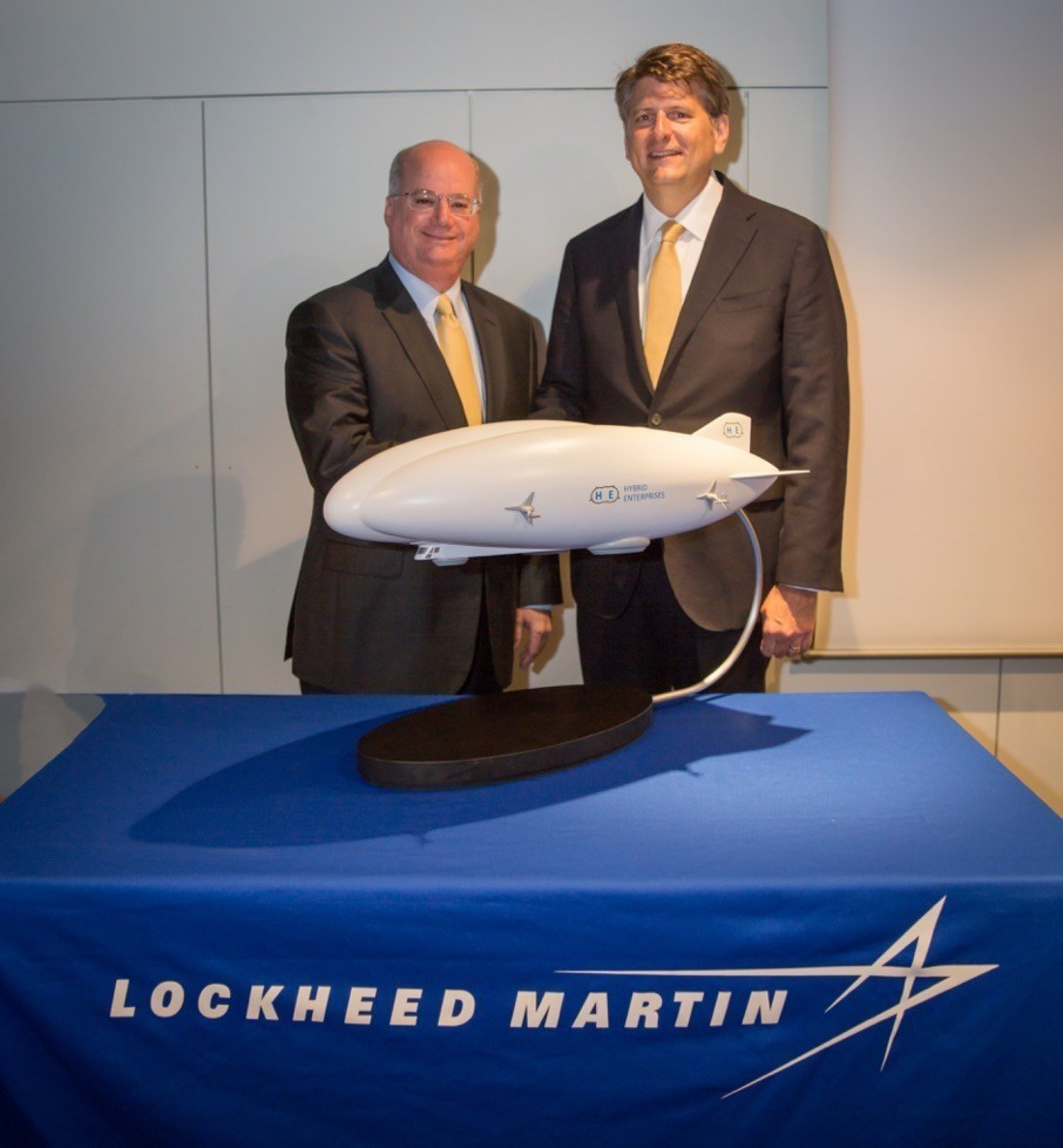 Orlando Carvalho (left), executive vice president of Lockheed Martin's Aeronautics business, and Rob Binns, chief executive officer of Hybrid Enterprises, with a  model of Lockheed Martin's Hybrid Airship after signing a strategic alliance wherein Hybrid Enterprises will be the exclusive, authorized reseller of Lockheed Martin's Hybrid Airships.