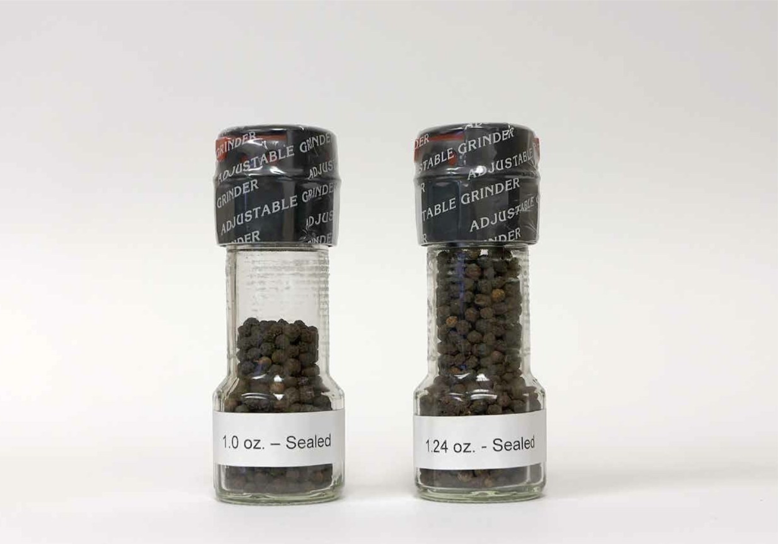 Exhibit B: Photo of the original 1.24 oz. McCormick black peppercorn grinder and the now 20% content reduced-size ("slack filled") 1 oz. McCormick black pepper grinder in sealed bottles. Only the facial label has been removed to show slack-fill.