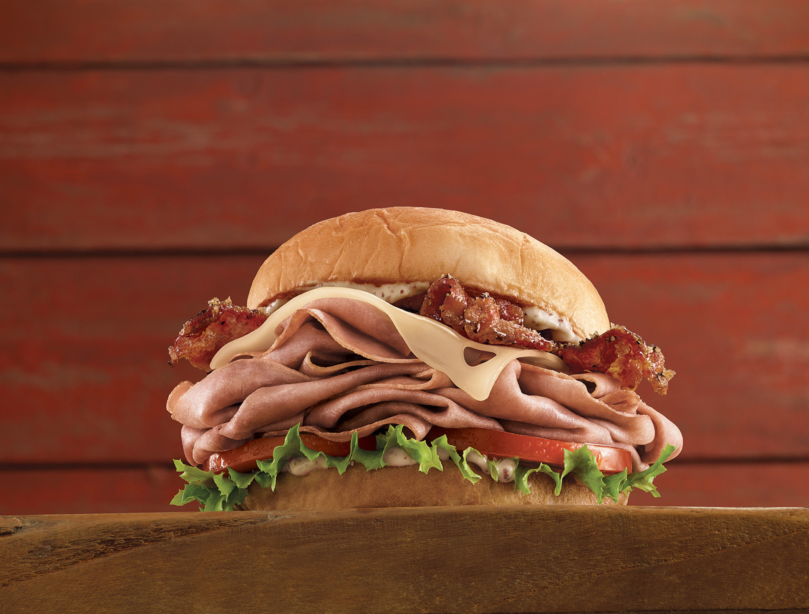 Brown Sugar Bacon & Roast Beef: thinly-sliced signature Arby's roast beef topped with brown sugar bacon, Swiss cheese, mild and creamy Dijon mustard, lettuce and tomato on a sweet, fluffy King's Hawaiian bun.