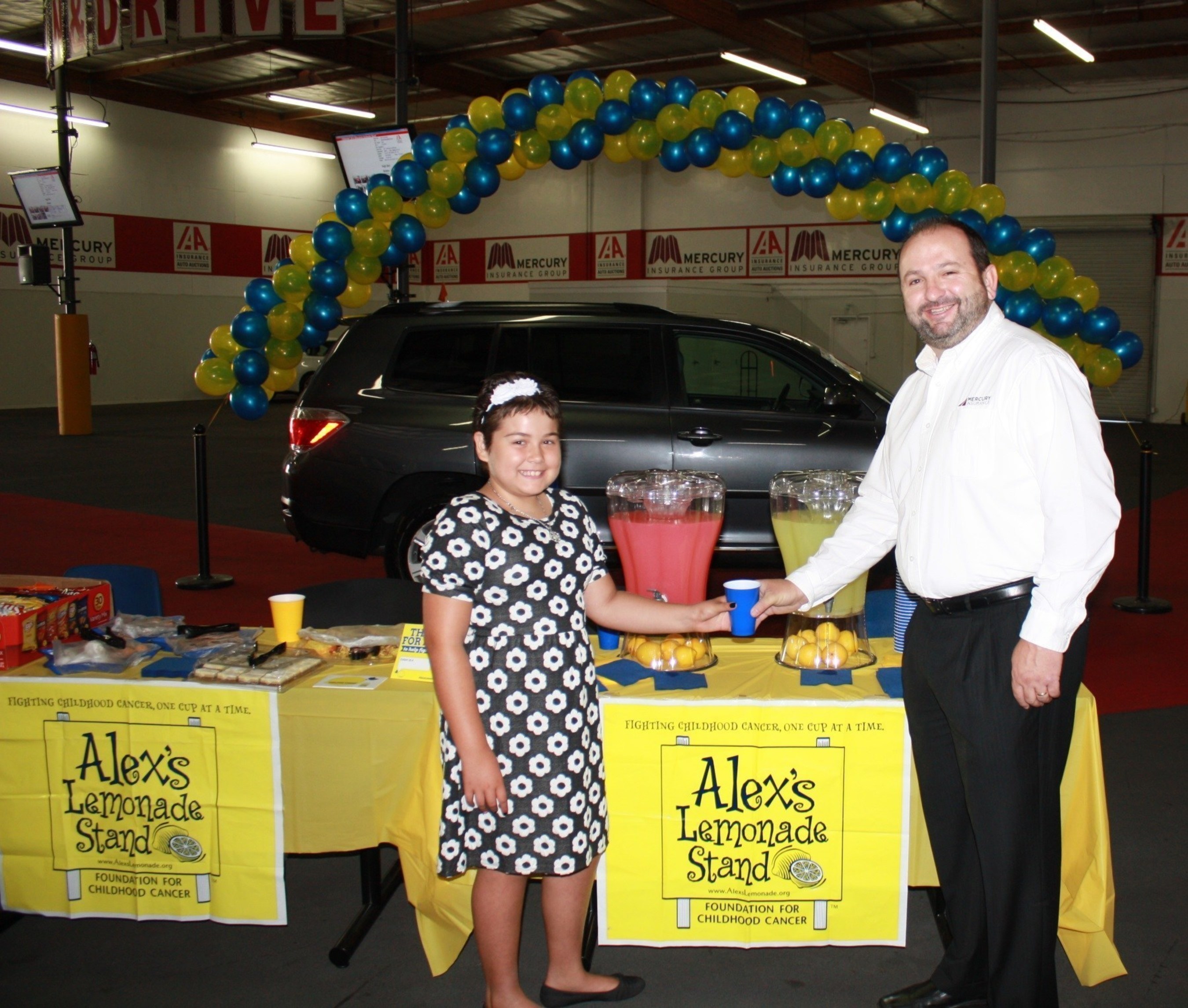 Alex's Lemonade Stand Foundation Hero Karah Casas serves lemonade to Mercury's Jim Bohn at vehicle auction that helped raise $14,700 for childhood cancer research.