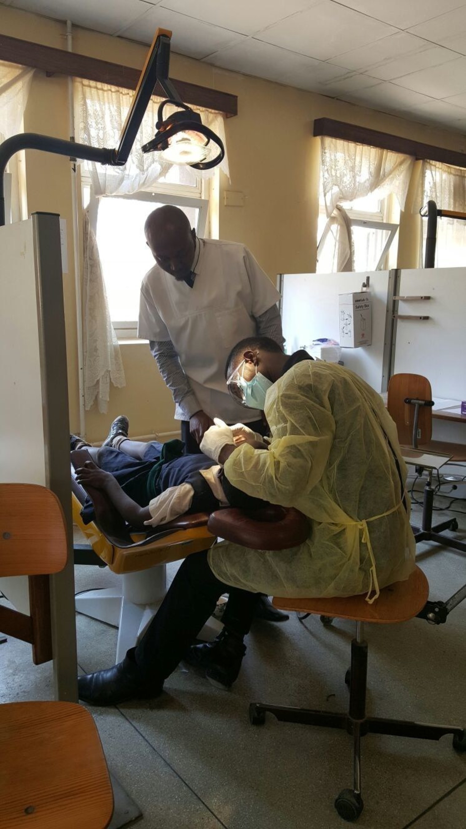 A third year Dental Therapy Student provides free dental treatment to a primary school student under the supervision of the Dental Therapy School Principal.