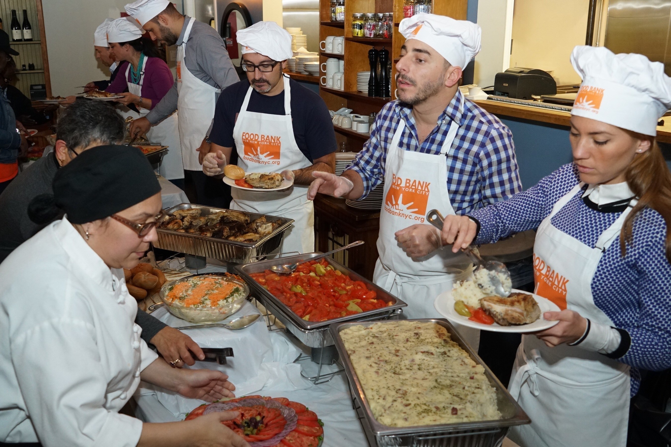 Chef Jordi Roca and BBVA Compass employees help serve hot meals to 100 seniors at the Food Bank for New York City's West Harlem Community Kitchen.