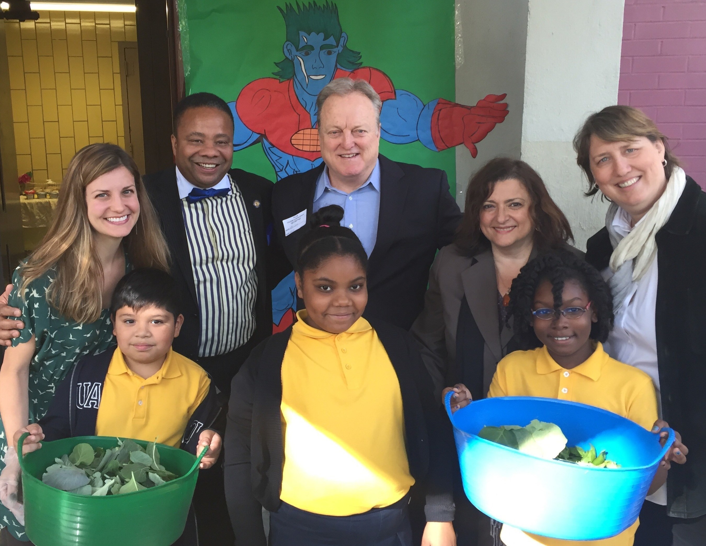 From left to right, Julie Kowalchick, PS 316 Elijah Stroud Elementary School Science Teacher, NY State Senator Jesse Hamilton, Larry White - VP Sales, Dole Packaged Foods, Principal Olaf Maluf, PS 316 and Leesa Carter, Executive Director, Captain Planet Foundation are joined by students from PS 316 Elijah Stroud Elementary School with salad greens from their new Learning Garden funded by Dole Packaged Foods and Key Food Stores.