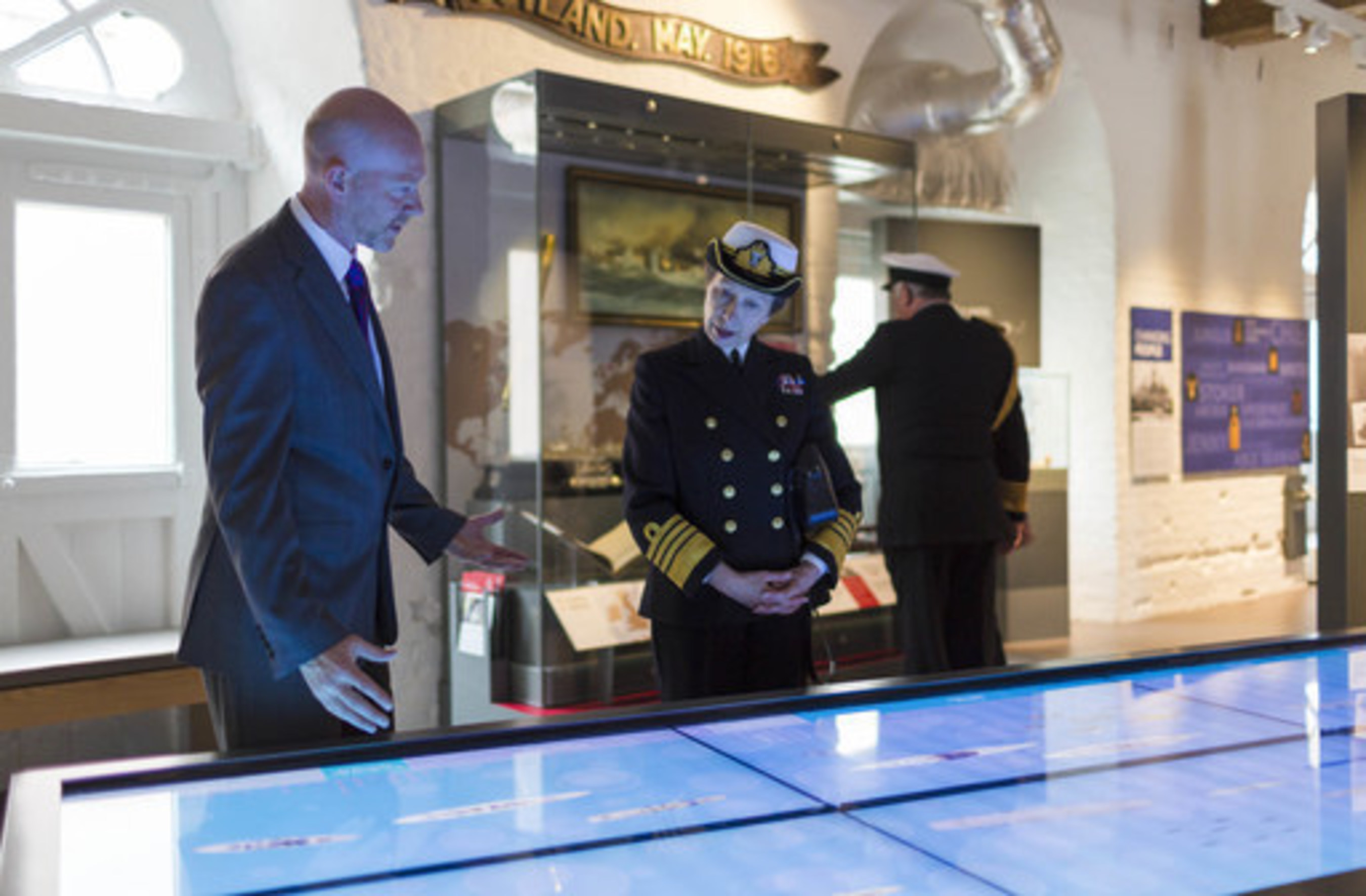Project Director Matthew Sheldon shows HRH Princess Anne interactive HMS timeline at the National Museum of the Royal Navy.