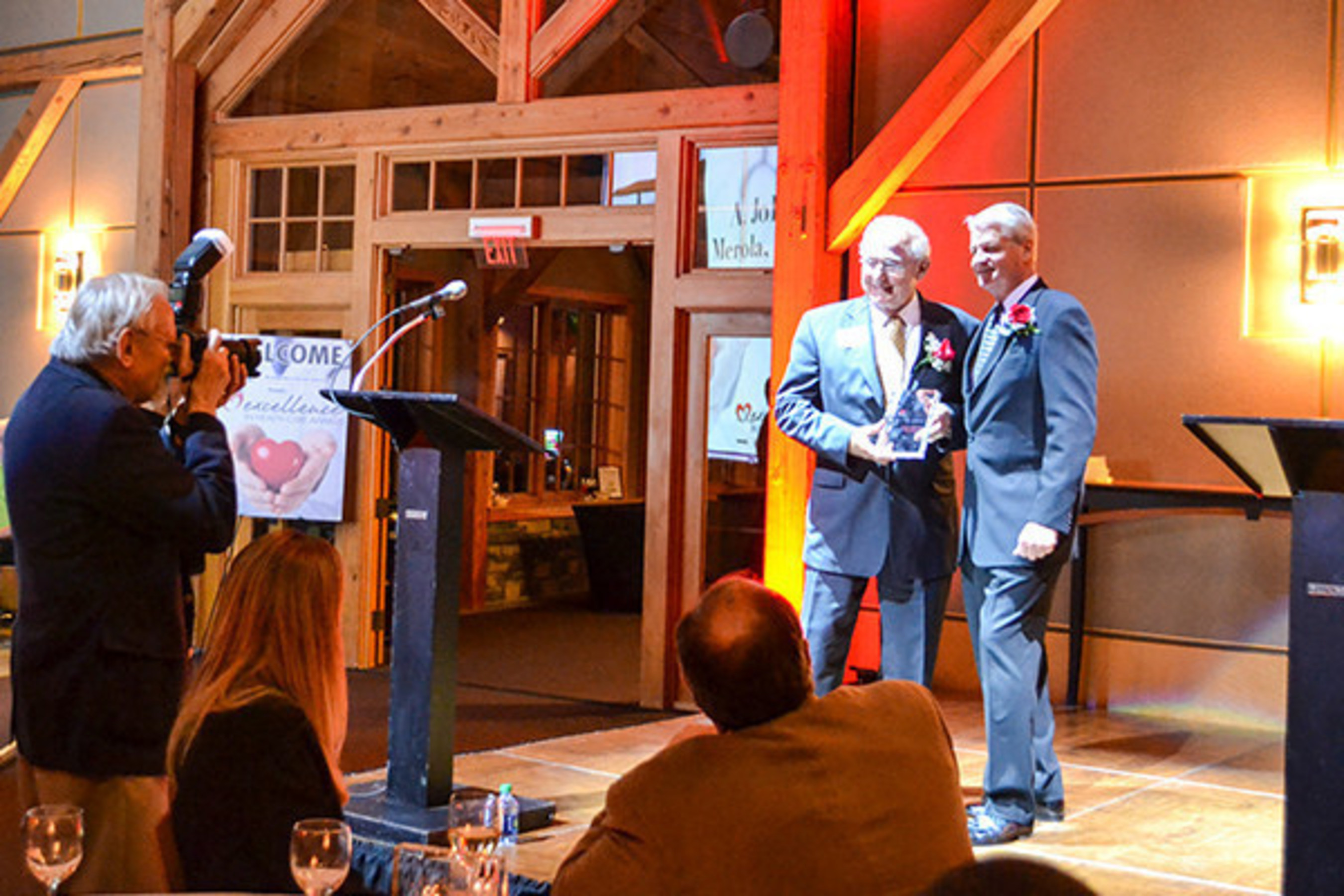 Scott Brennan of Bankers Healthcare Group (right) presents Dr. A. John Merola (left) with the inaugural Lifetime Health-Care Achievement Award and announces that the award will carry his name going forward: the Dr. A. John Merola Lifetime Health-Care Achievement Award.
