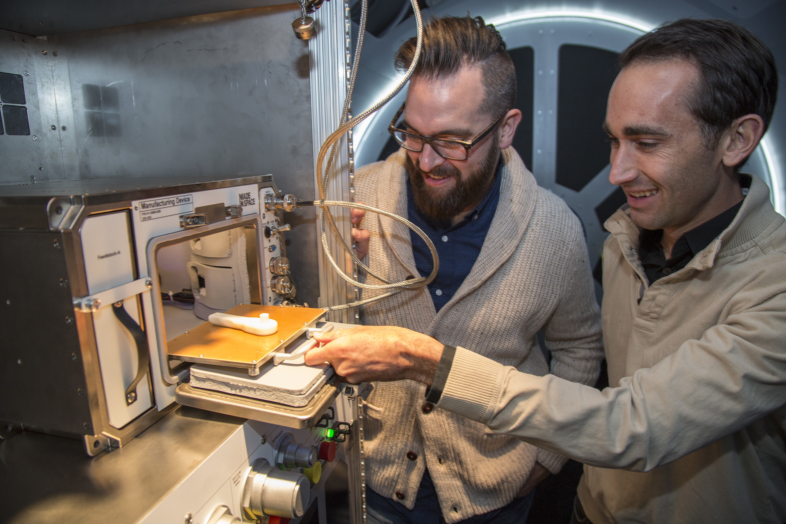 Kyle Nel, executive director, Lowe's Innovation Labs, left, and Jason Dunn, CTO and co-founder, Made in Space, examine a 3D printer in a mock-up of the International Space Station (ISS) in New York on Wednesday, October 28, 2015. Lowe's Innovation Labs (http://www.lowesinnovationlabs.com), the disruptive innovation hub of Lowe's Companies, Inc., has partnered with aerospace company Made in Space, to become the first to launch a commercial 3D printer to space.  The printer, the first permanent additive manufacturing facility for the ISS, will bring tools and technology to astronauts in space.