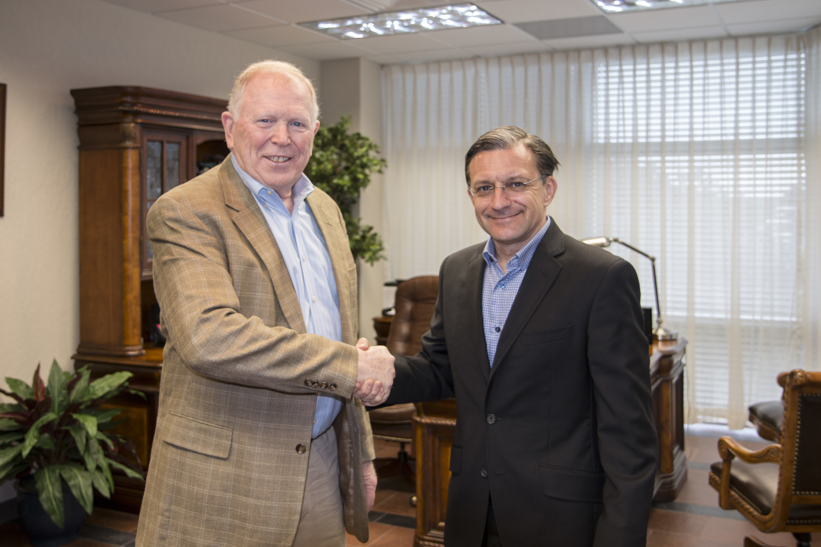 ADU's President, Dr. David Greenlaw and Pearson Online Learning Services COO, Todd Hitchcock shake hands as they renew their partnership.