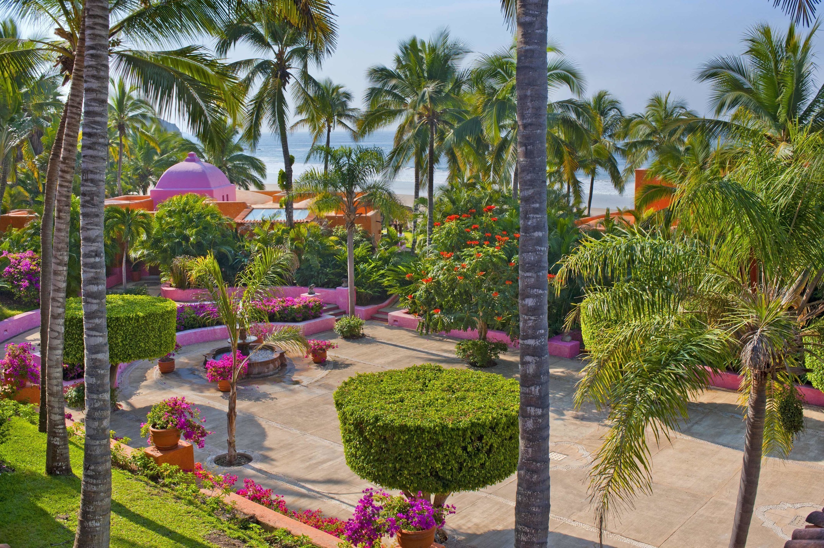 The fountains and lush gardens of Plaza De Los Delfines at Las Alamandas Resort.