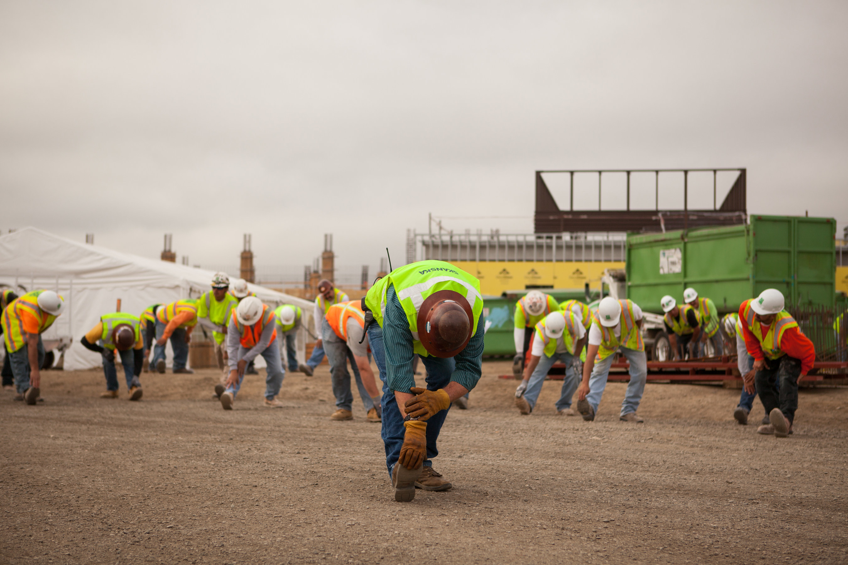 Safety first! Construction workers at Skanska stretch and prepare for their day. Photo Credit: Diana Rothery