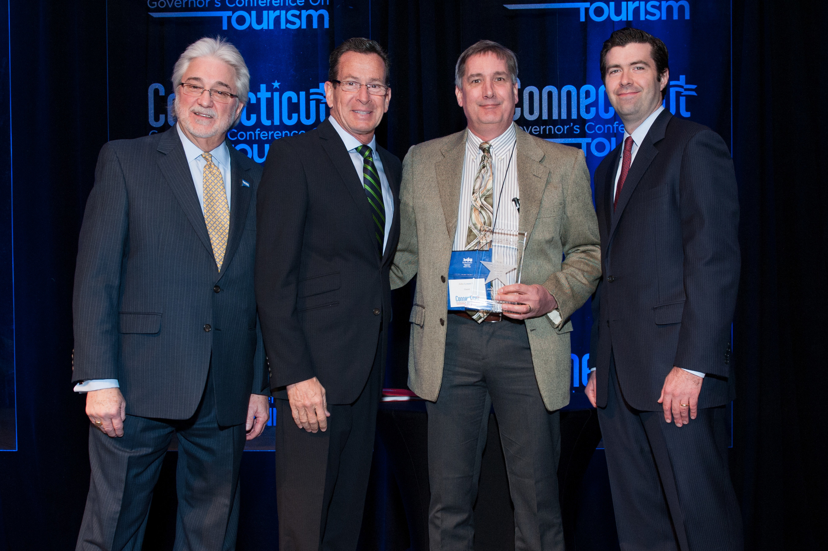 John Lyman III, Executive Vice President of Lyman Orchards (Middlefield) receives the 2016 Connecticut Governor's Tourism Award for Tourism Legacy Leader. From left: Randy Fiveash, Director, Connecticut Office of Tourism; Governor Dannel P. Malloy; John Lyman III, Executive Vice President, Lyman Orchards; Tim Sullivan, Deputy Commissioner, Connecticut Department of Economic and Community Development.