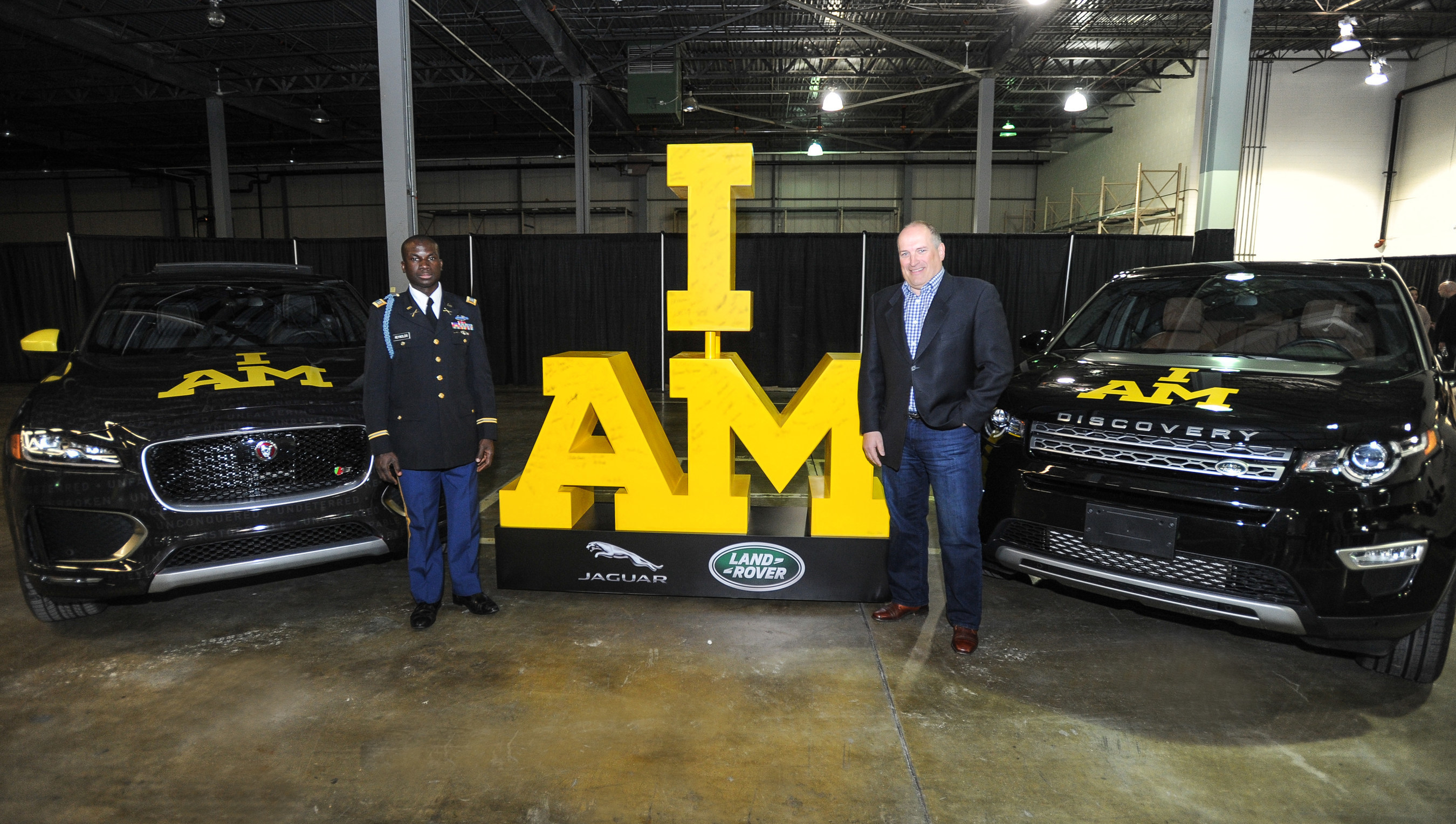 Will Reynolds, Captain of the 2016 U.S. Invictus Team (L) and Joe Eberhardt, President and CEO, Jaguar Land Rover North America (R) pose with new Jaguar F-PACE SUV, and a Land Rover Discovery Sport, ahead of the 2016  Invictus Games, the international sporting event for Wounded, Ill and Injured Service Members - presented by Jaguar Land Rover - which will take place in Orlando, FL May 8-12.