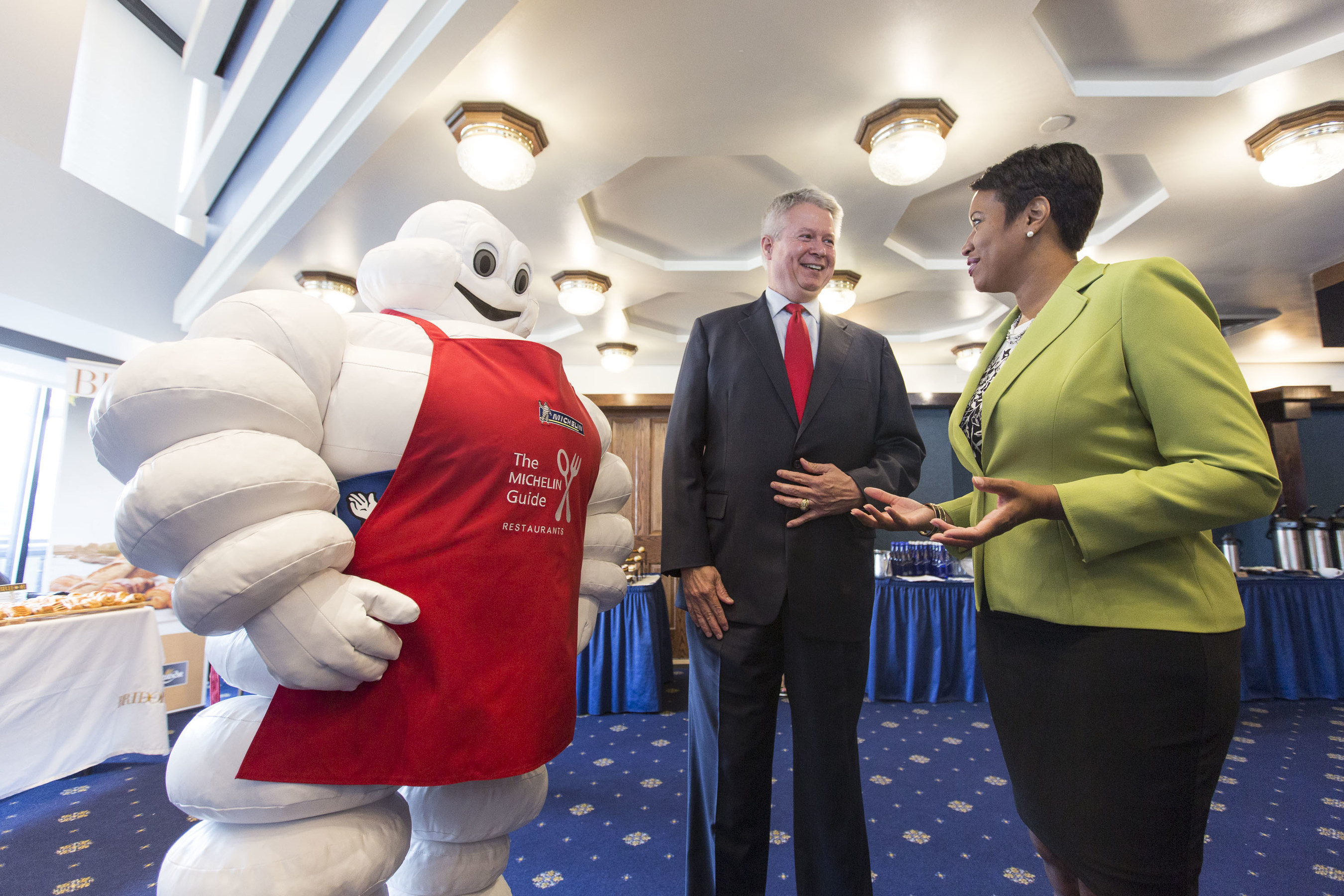 DC Mayor Muriel Bowser and Michelin CEO Pete Selleck are greeted by the Michelin Man at a press conference announcing the arrival of the Michelin Guide to Washington, DC at the National Press Club, May 31, 2016.