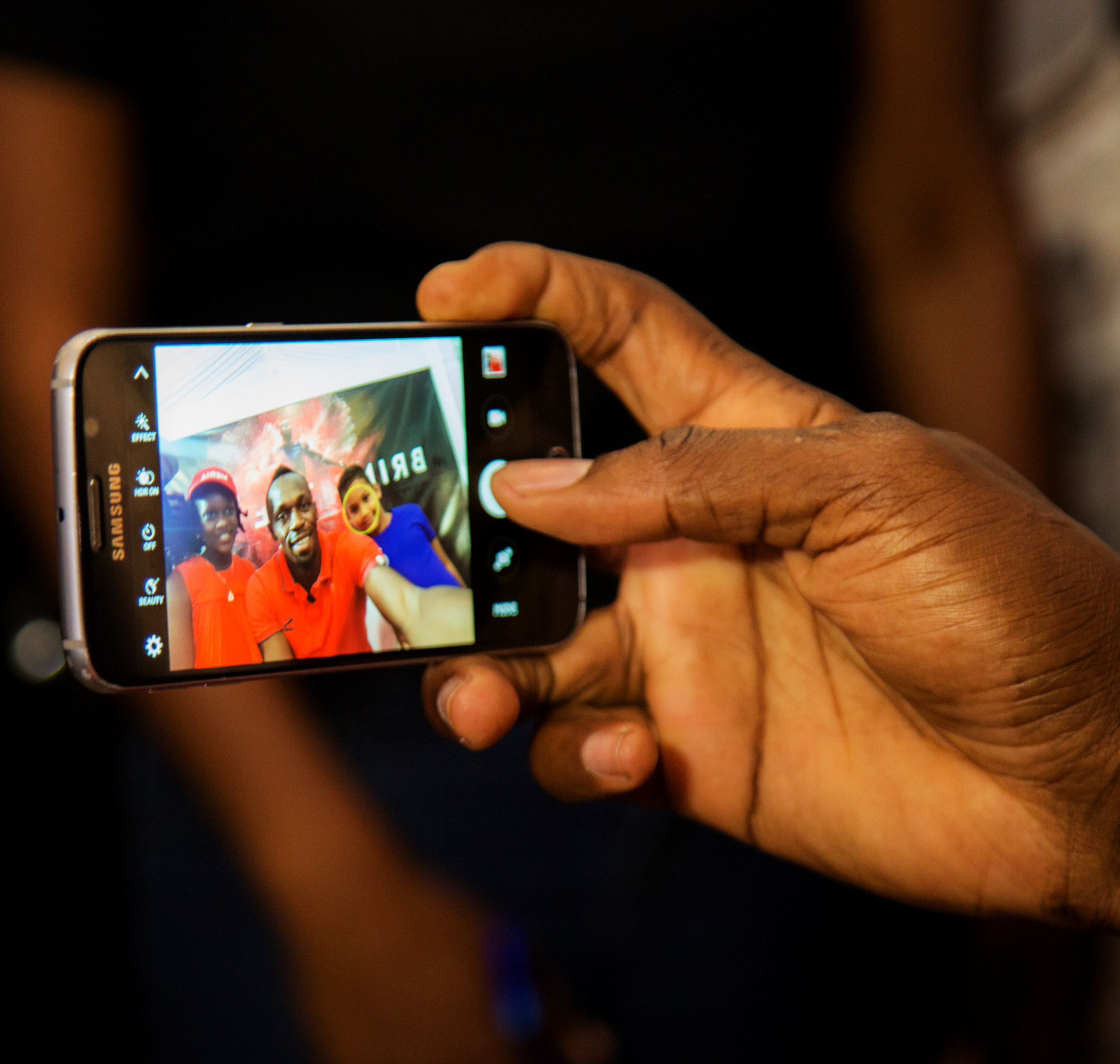 Having asked if Usain would be friends with him on Facebook, seven year-old Ajani Brown from Jamaica scores a selfie with Usain Bolt and kiddie moderator for the Digicel "Bring the Beat" press conference, nine year-old Naleighna-Kae McLean.