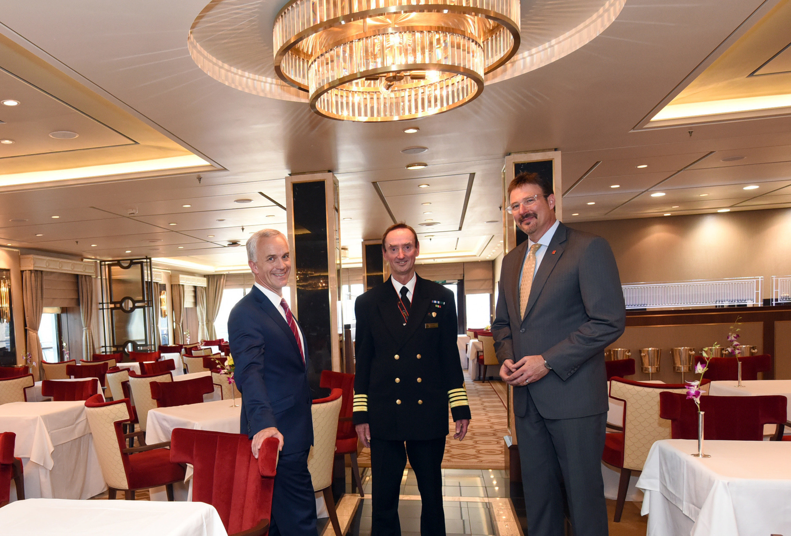 David Noyes, left, CEO, Cunard, Captain Christopher Wells, center, and Richard Meadows, right, President, Cunard, North America, pose for a photo in the Queens Grill restaurant aboard the remastered Queen Mary 2, Wednesday, July 6, 2016, at Brooklyn Cruise Terminal in New York, its U.S. homeport. The Queen Mary 2 spent 25 days in dry dock and a refit that cost in the region of $132 million, renovating its staterooms, restaurants and public areas. (Diane Bondareff/AP Images for Cunard)