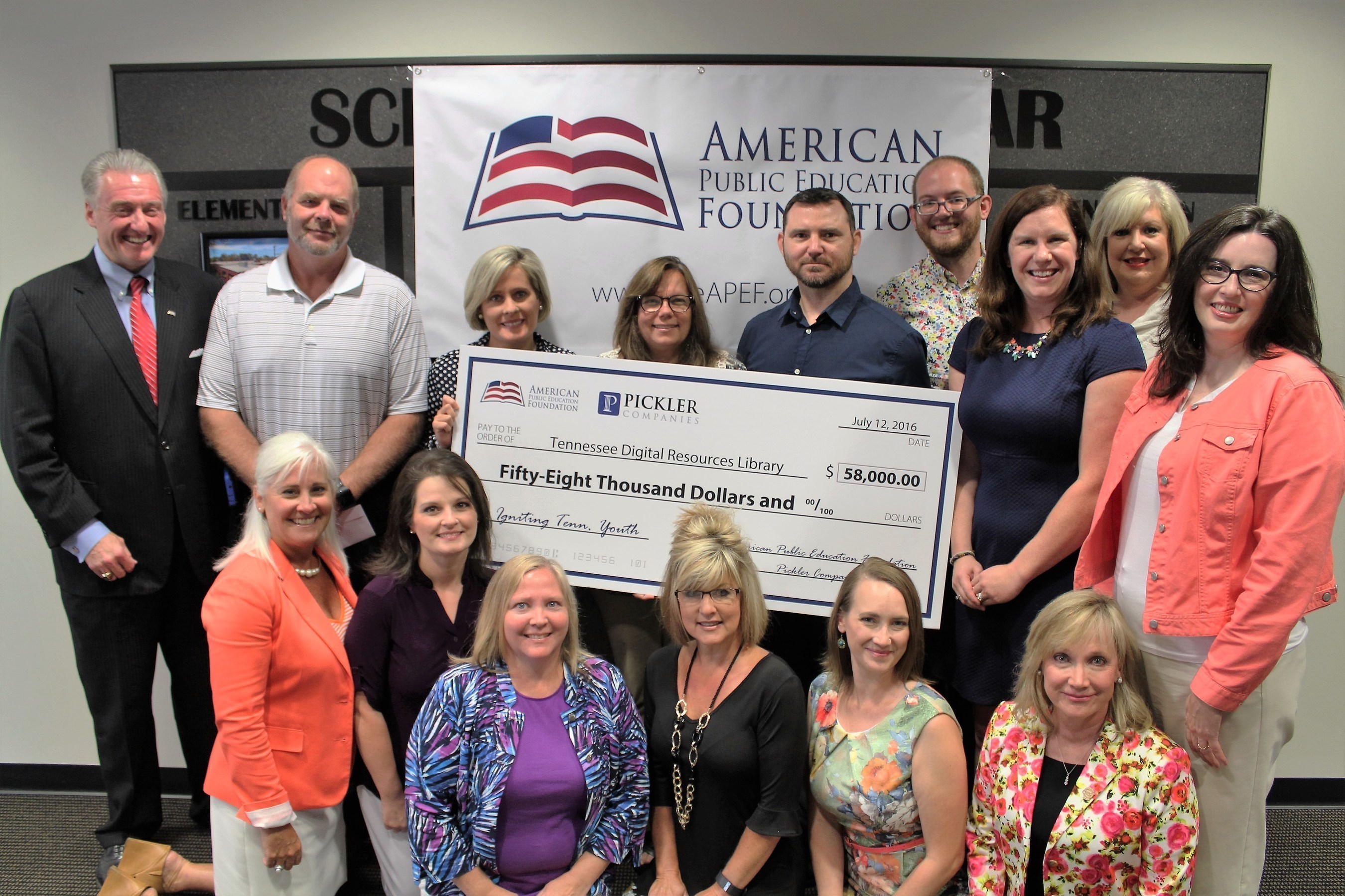 David Pickler, J.D., President, American Public Education Foundation (top left), presents a $58,000 check and iPad Air 2s to the 58 Tennessee high school teachers (partial group shown) who curated digital content for the Tennessee Digital Resources Library. Also shown (lower left) is Tammy Grissom, Ed.D., Executive Director, Tennessee School Boards Association.