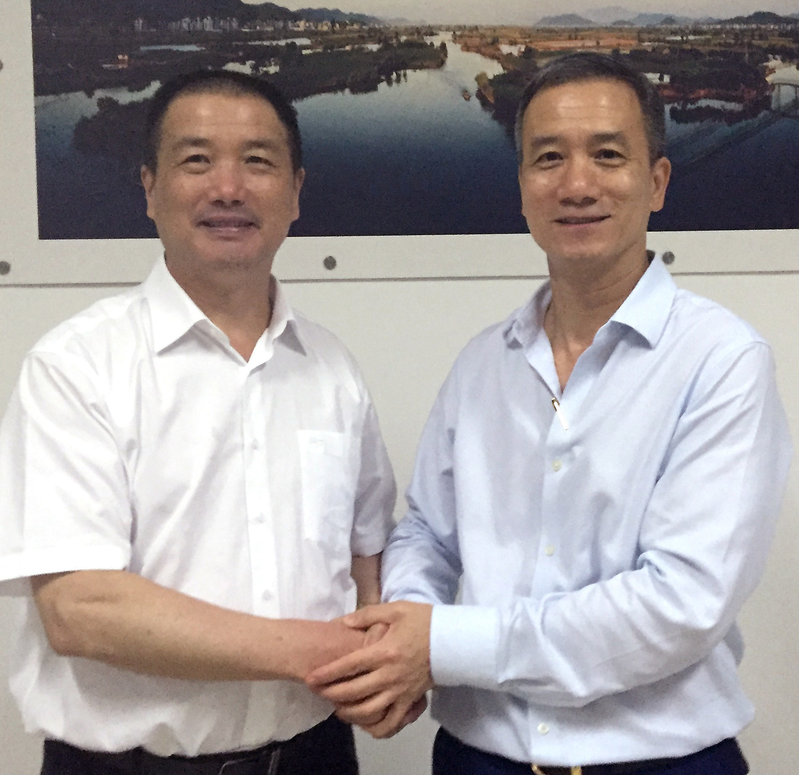 Lixiang Chen (left), Chairman of Zhejiang VIE Science & Technology CO., Ltd., and VIE Group CO., Ltd., shaking hands with KwokYin Chan (right), CEO of Protean Electric, after signing the investment agreement and JV contract at Zhejiang VIE Science & Technology Co. Ltd.