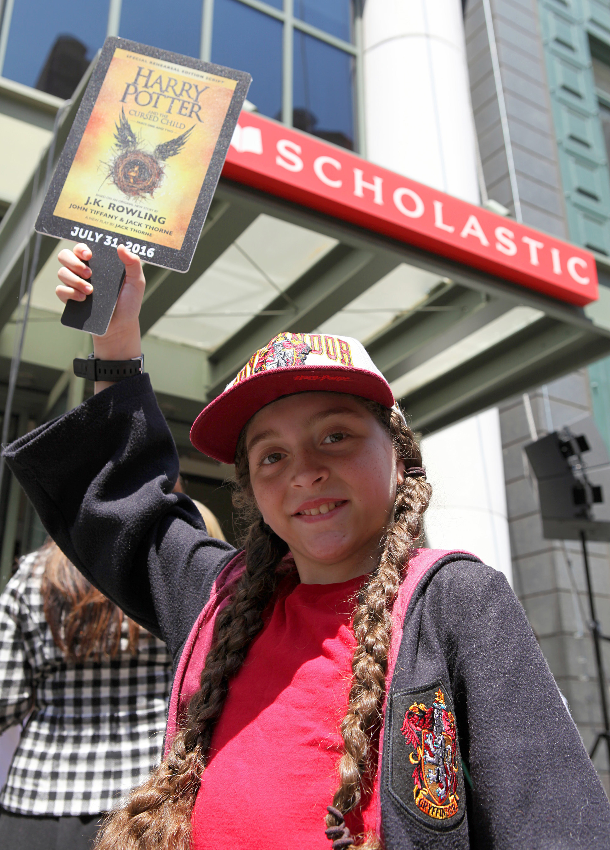 A Scholastic employee's daughter, 10-year-old Ella, joins the "Muggle Mob" of 300 Harry Potter fans in front of the Scholastic headquarters building in New York City on July 21, celebrating the upcoming release of "Harry Potter and the Cursed Child Parts One and Two," the eighth story, on July 31, 2016 at 12:01 a.m. ET. Credit: Scholastic