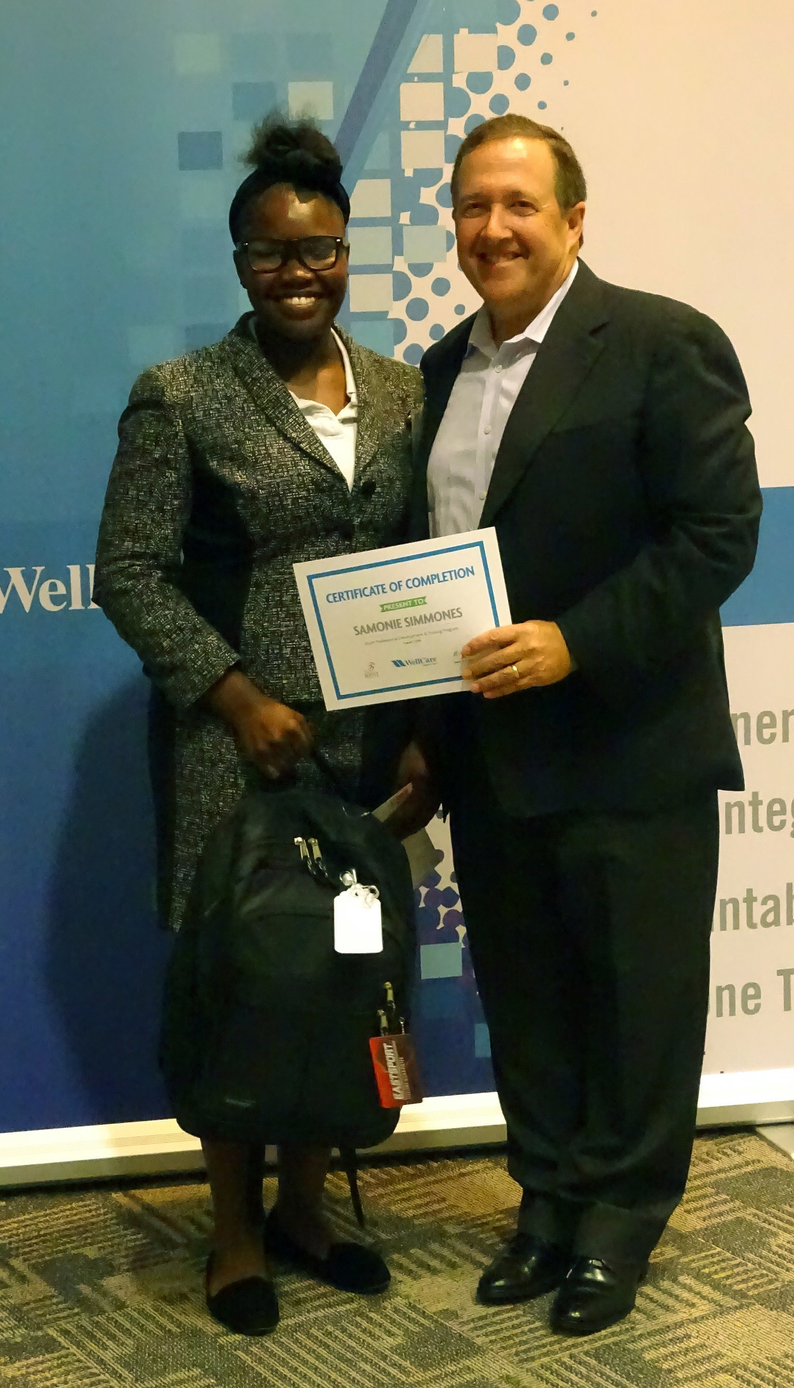 On Aug. 1, 16-year-old Samonie Simmons accepts her graduation certificate from WellCare CEO Ken Burdick.