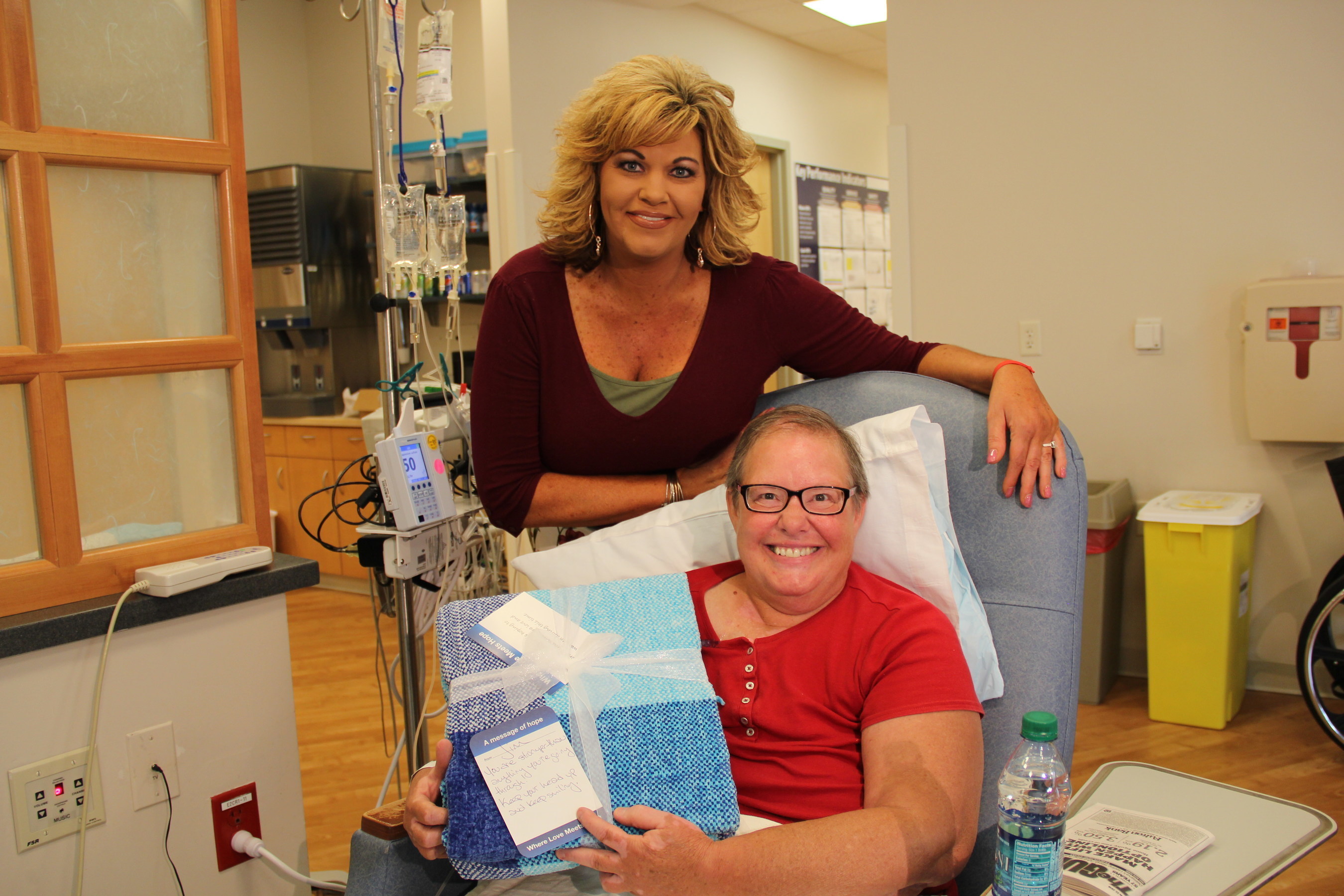 Wendy Schiavone, Sales Manager at Gateway Subaru, donates the first blanket to patient Brenda Rathel of Hebron, MD.
