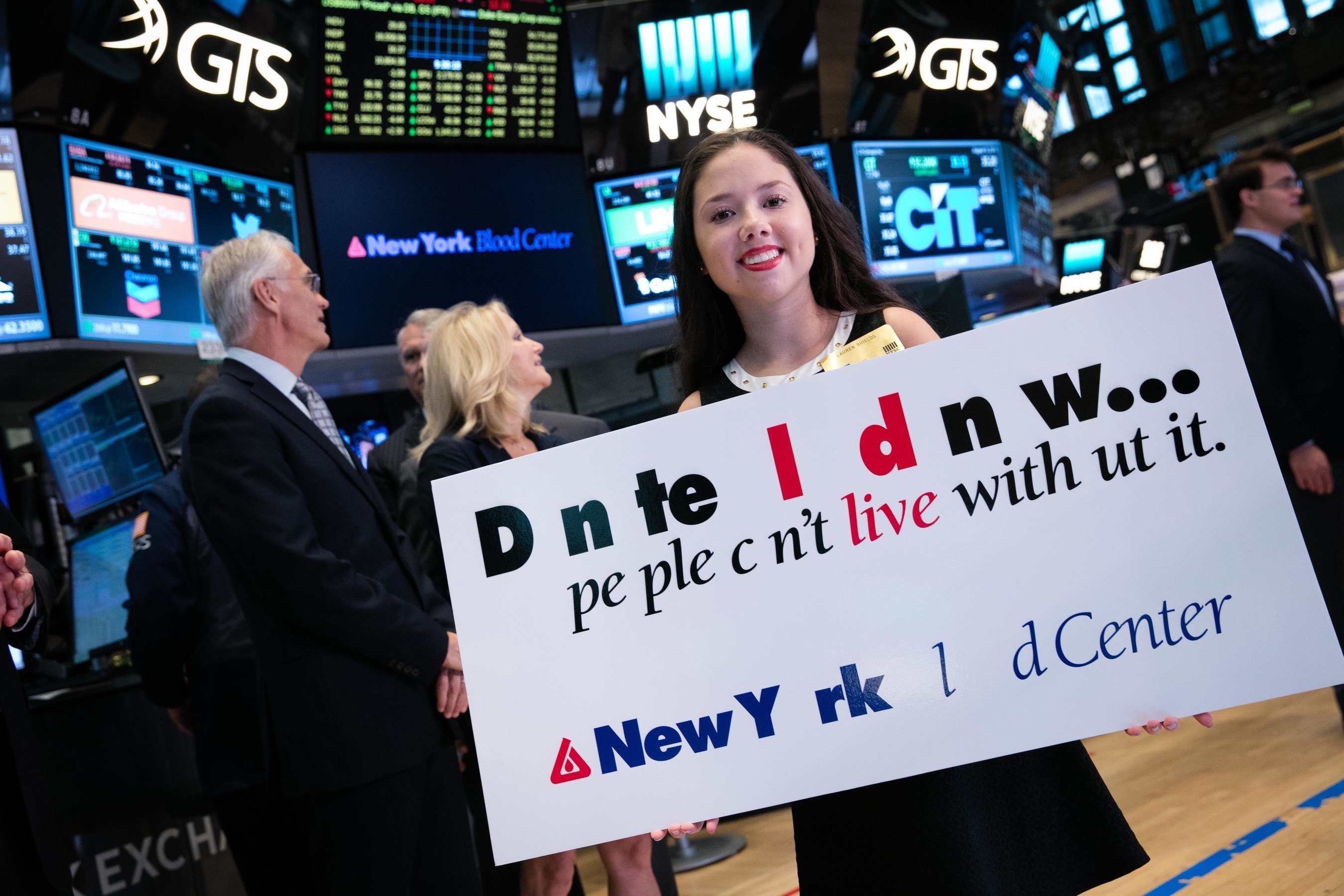 Lauren Shields holds the #MissingType sign during the New York Blood Center's ringing of the opening bell at the New York Stock Exchange on Tuesday, August 9th.