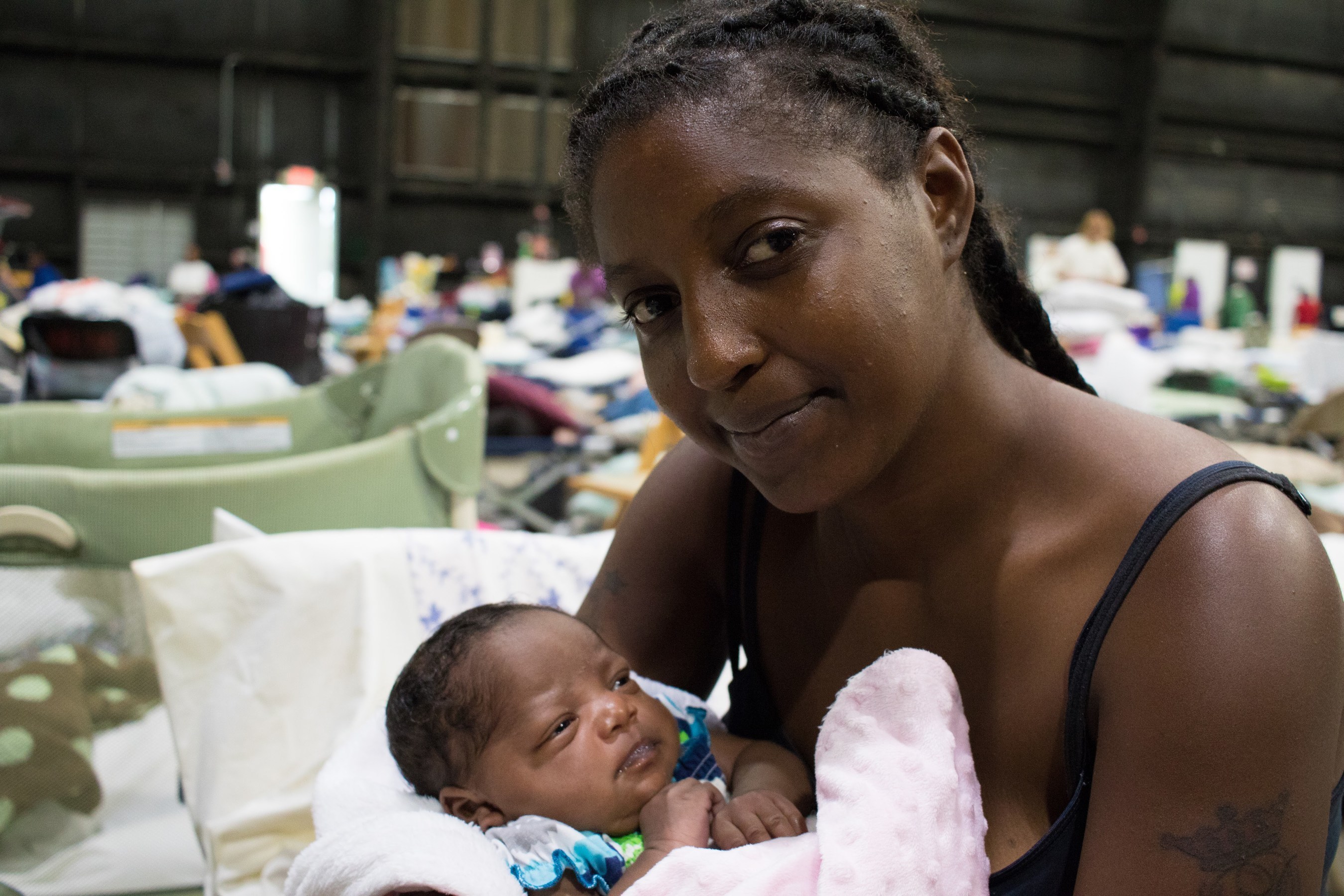 Vernesha and her 3-week-old baby niece, Joy, are staying at a shelter in Baton Rouge after being driven from their home by rising floodwaters on Saturday, Aug. 13. They live together with Joy's mother and two older sisters in an apartment that is now underwater. Photo by Stuart Sia / Save the Children.
