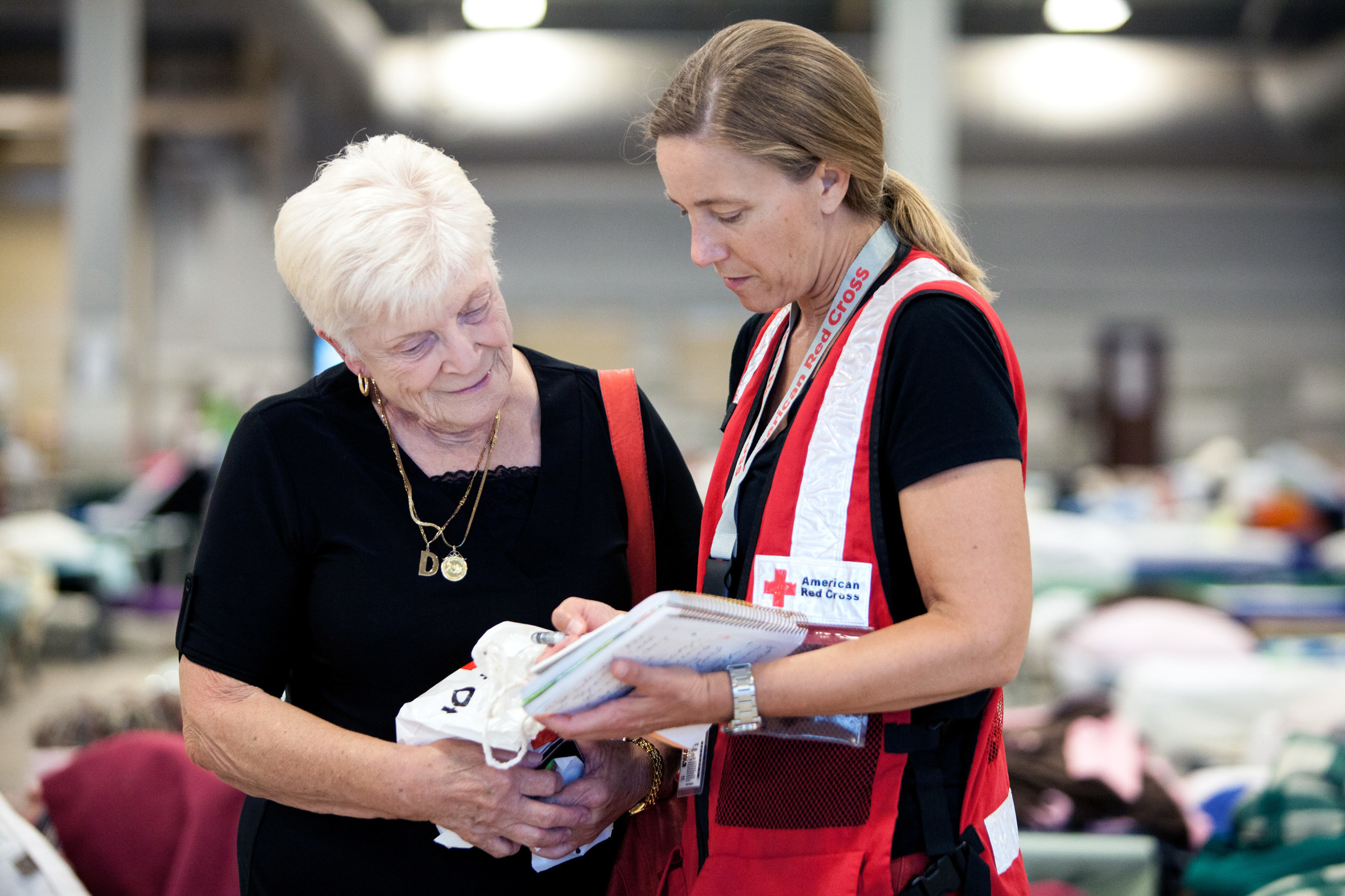 Doreen Ulm, 81, survived air raids in London during World War II, and now because of the flooding in Louisiana, she's at a shelter for the first time since the war. She shared her story with Red Cross relief worker Lynette Nyman, at the Red Cross shelter in Gonzales, Louisiana. Red Cross Photo by Marko Kokic