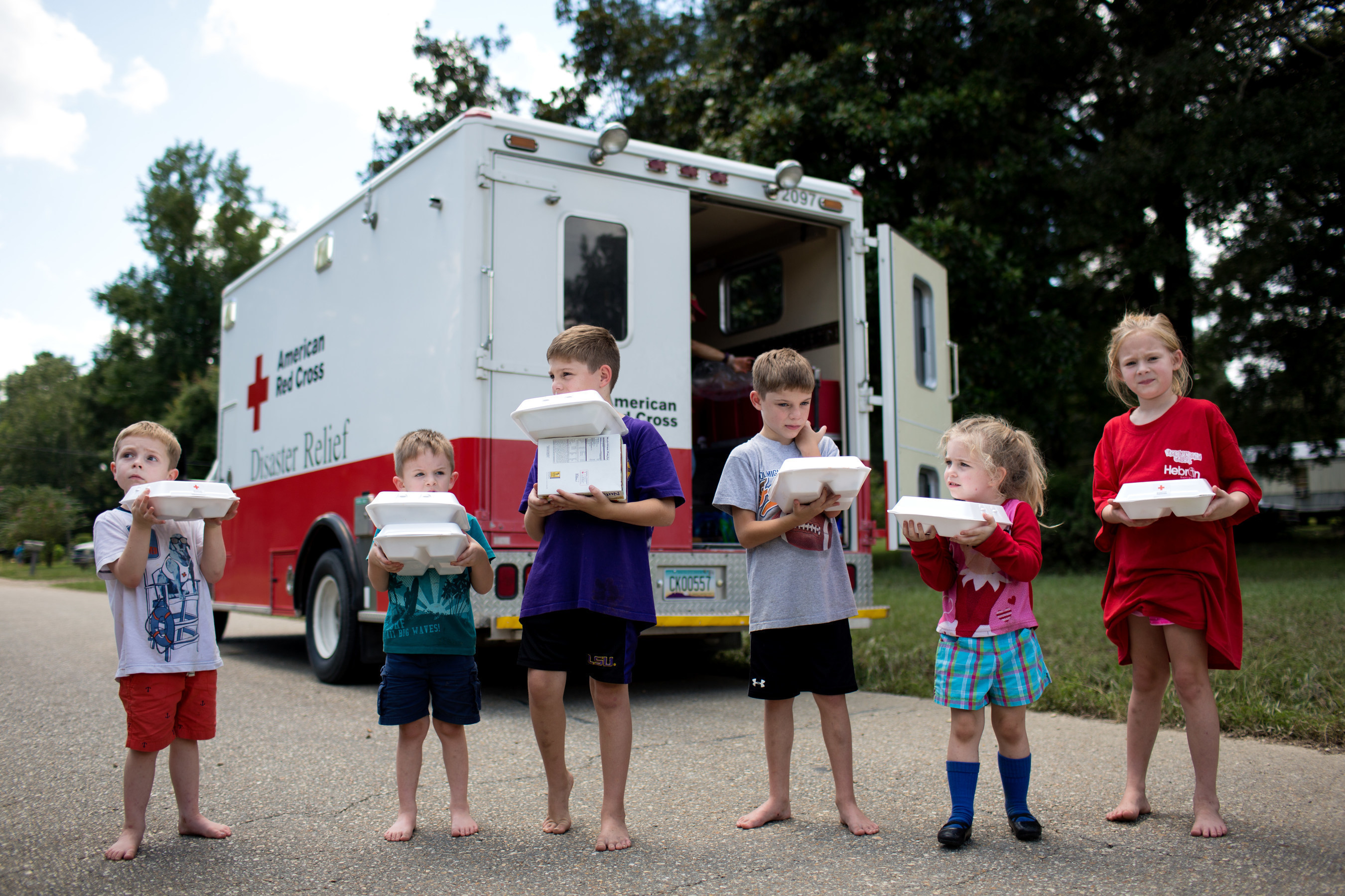 Children hold hot meals they received from the Red Cross in Denham Springs, a town hit hard by flooding across southern Louisiana. Red Cross photo by Marko Kokic