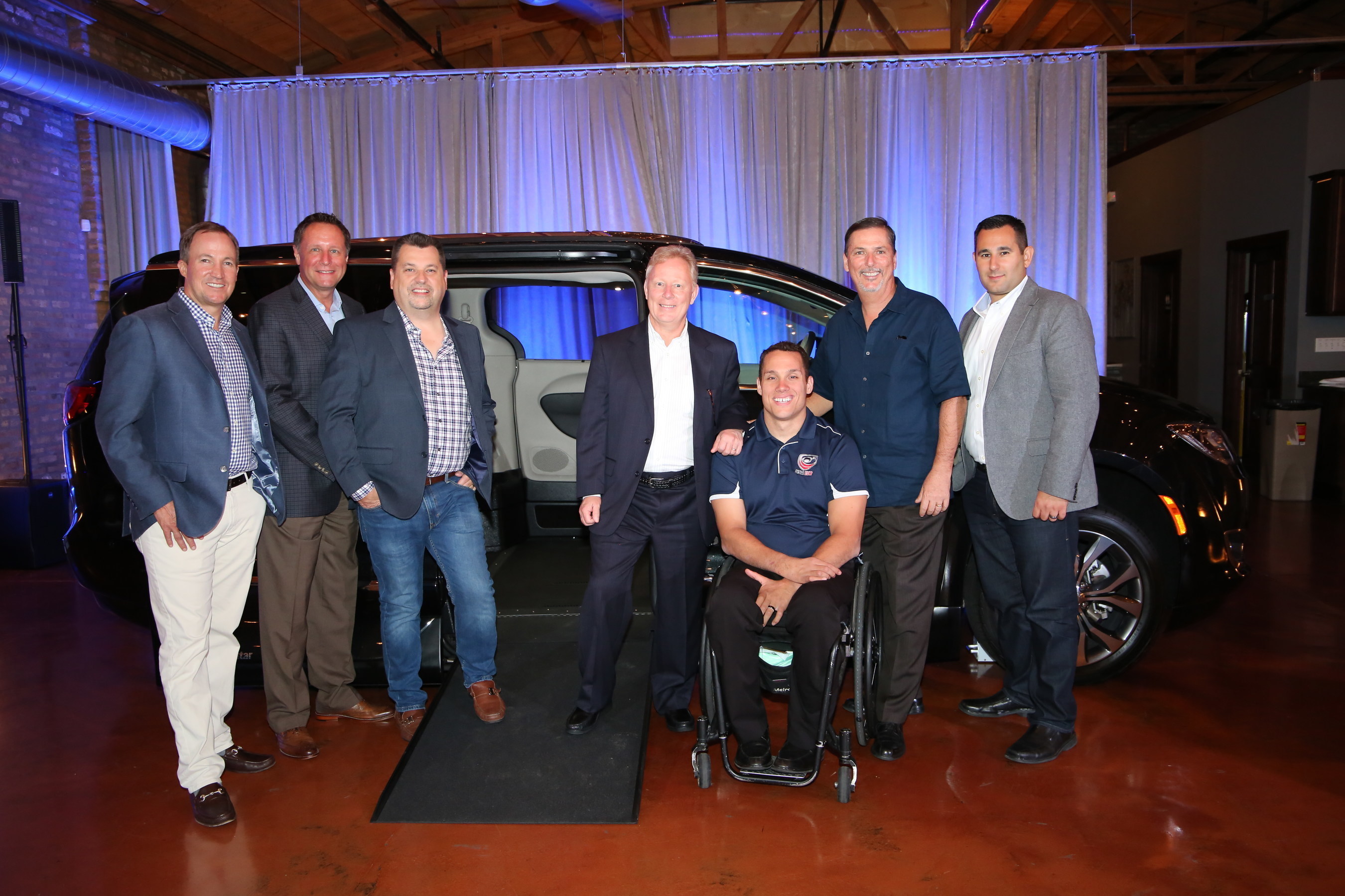 VMI introduces industry's first Chrysler Pacifica side-entry conversion to the Dealer Council Executive Committee in Chicago, Il.  Shown here at the event are from left, Doug Eaton, VMI CEO, Michael Ring, FCA, Steve Crandell, VMI COO, Len Norton, Chairman of VMI Dealer Council, Joe Delgrave, Team USA, Paralympian and new VMI spokesperson, Tim Barone, VMI CFO, and Matt Huber, FCA.