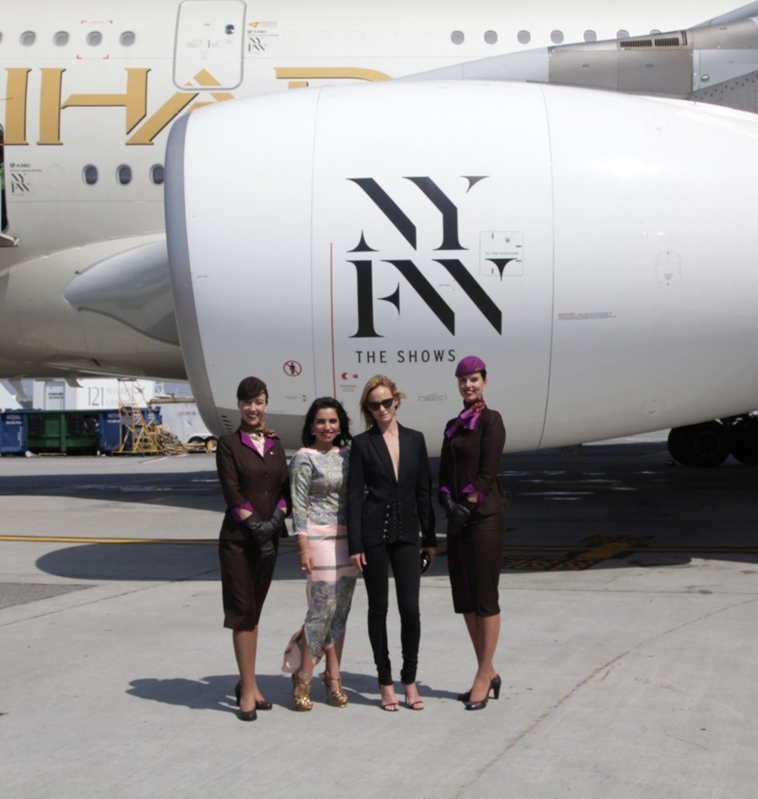 (From left to right flanked by cabin crew) From runway to runway, Amina Taher, Head of Corporate Communications - Etihad Airways and Supermodel Amber Valletta unveil the airline's A380 livery, featuring an "NYFW: The Shows"- branded logo on the aircraft engines and doors at JFK International Airport.