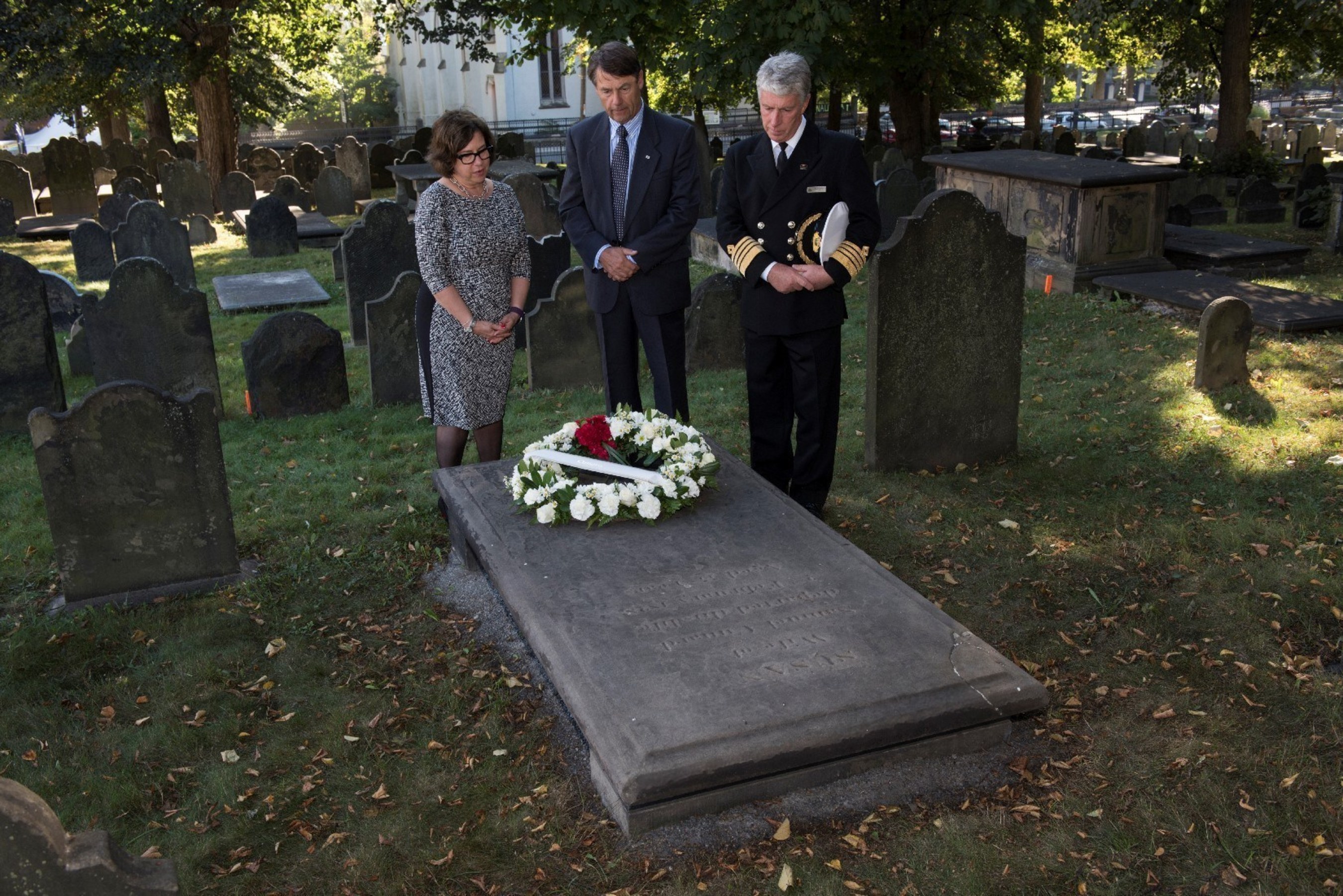 As part of today's commemorative activities, Cunard paid tribute to the legacy of Samuel Cunard and wife, Susan, by laying a wreath on Suan's gravesite. Pictured: Captain Kevin Oprey, Master of Queen Mary 2, Cunard historian John Langley, and Cunard Public Relations Director Jackie Chase.