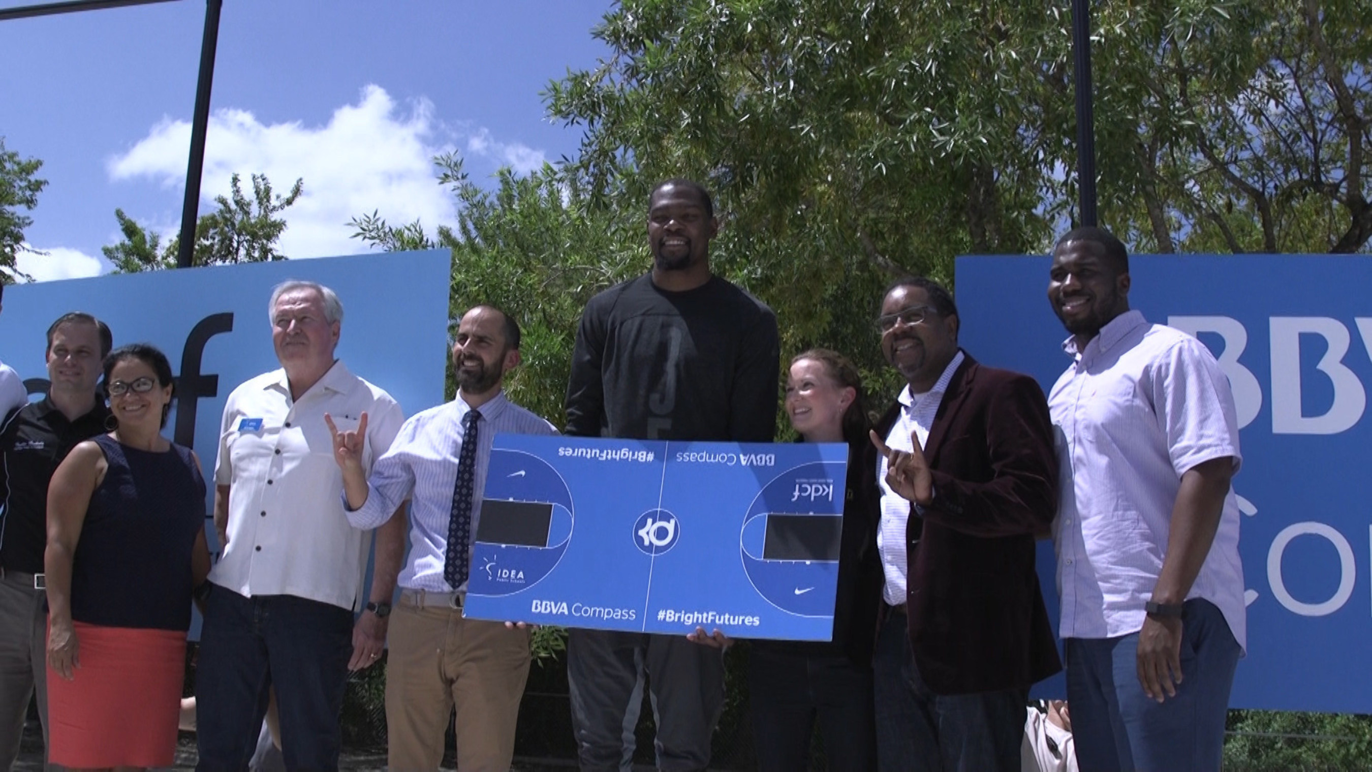 NBA All-Star Kevin Durant poses with IDEA Public Schools Austin Executive Director (left of Durant) and the IDEA Public Schools Austin Regional Board at the construction site of IDEA Rundberg Public School's new outdoor basketball court.