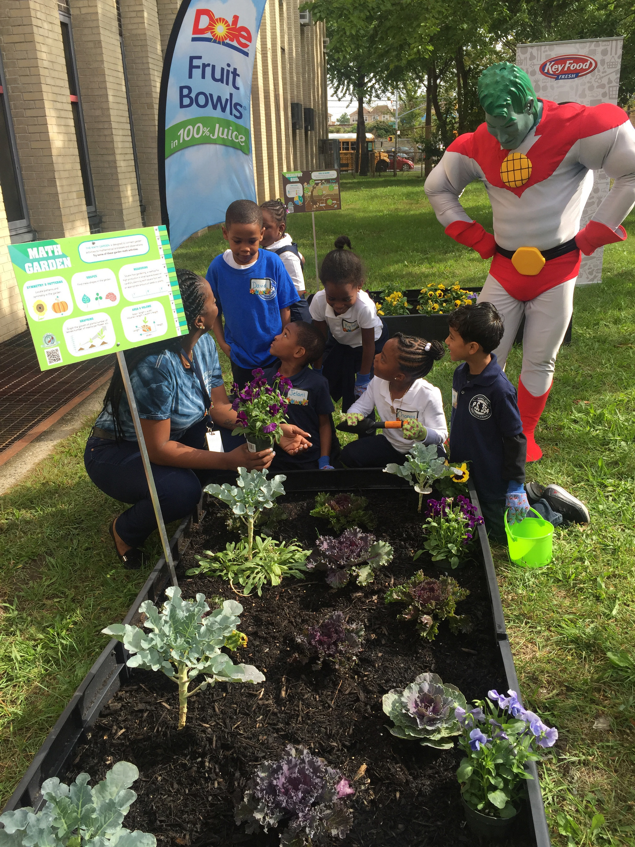 Kids from PS 354 STEM School of Queens learn first hand from their newly installed Learning Garden compliments of Dole Packaged Foods and Key Food as Captain Planet looks on.