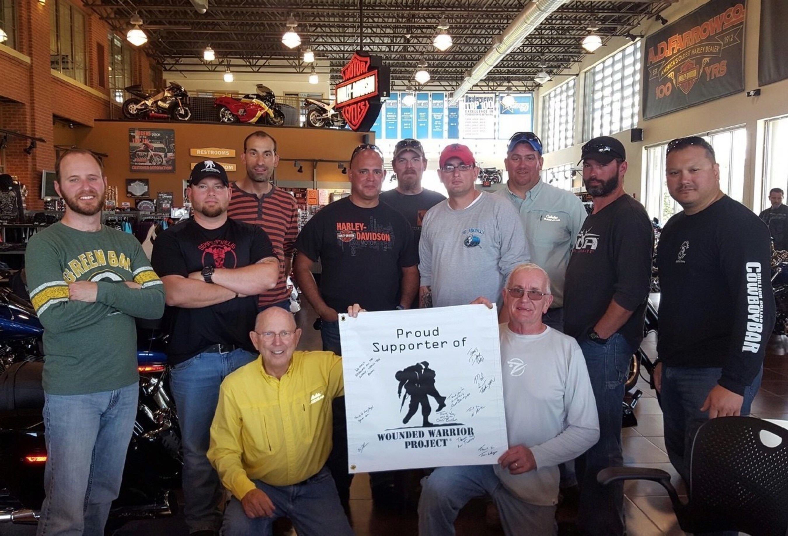 Wounded veterans pose with the Harley-Dealership team after a successful ride in Ohio.
