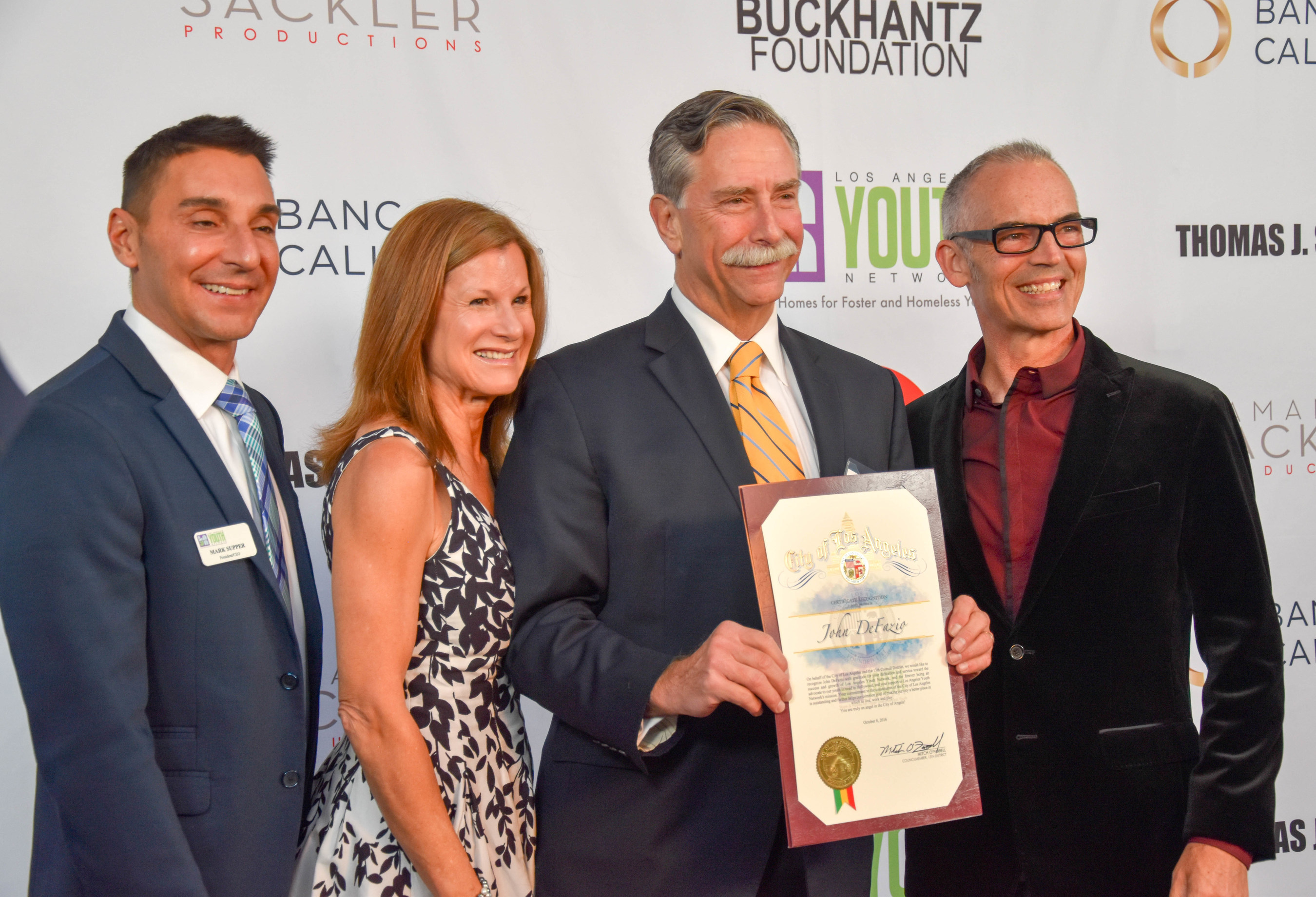 Los Angeles Youth Network CEO, Mark Supper and Councilman Mitch O'Farrell, present Key of Hope Award recipient, John DeFazio, of Heffernan Insurance Brokers and his wife, Donna DeFazio with a proclamation, during the 2016 Key of Hope Gala - Unlocking the Possibilities for Our Homeless and Foster Youth.