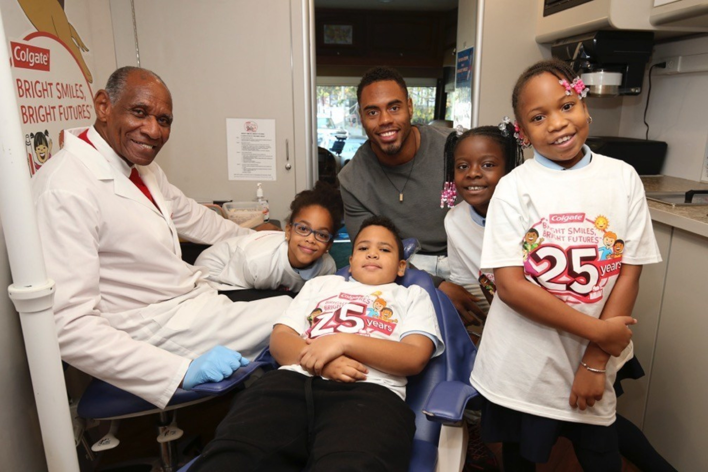 New York Giants running back Rashad Jennings (center) and Dr. Paul Martin (far left), a Colgate Bright Smiles, Bright Futures dental professional coordinator, remind P.S./I.S. 76 students about the importance of maintaining good oral health habits during the Bright Smiles, Bright Futures 25th Anniversary celebration in New York City. (Mark Von Holden/AP Images for Colgate Bright Smiles, Bright Futures)