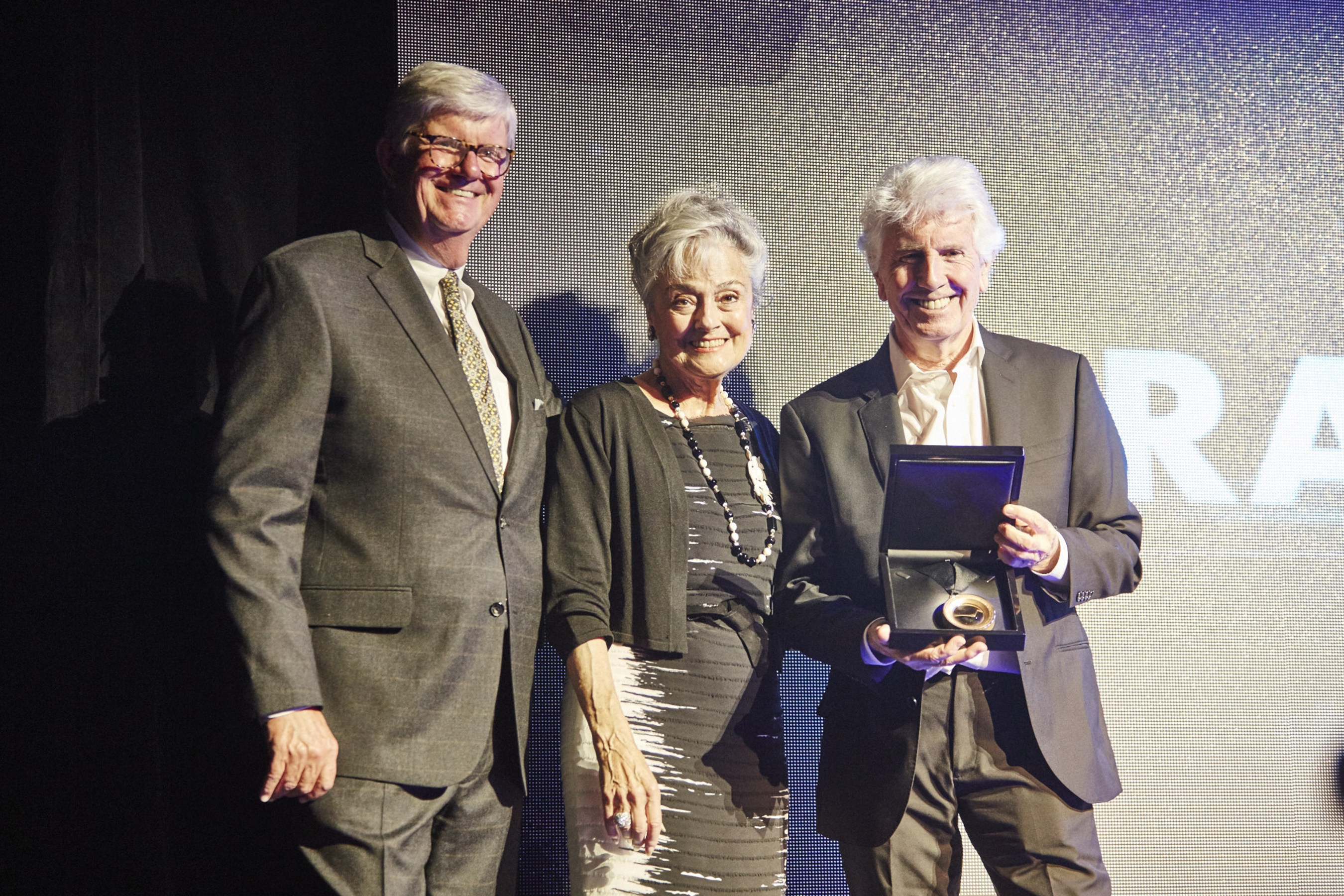(From left to right) Bob Bishop, chairperson of the 2016 Hall of Fame selection committee and Anna Harris, president of the International Photography Hall of Fame and Museum's (IPHF) board of directors, congratulate Graham Nash on his induction into the IPHF, located in St. Louis, Mo.