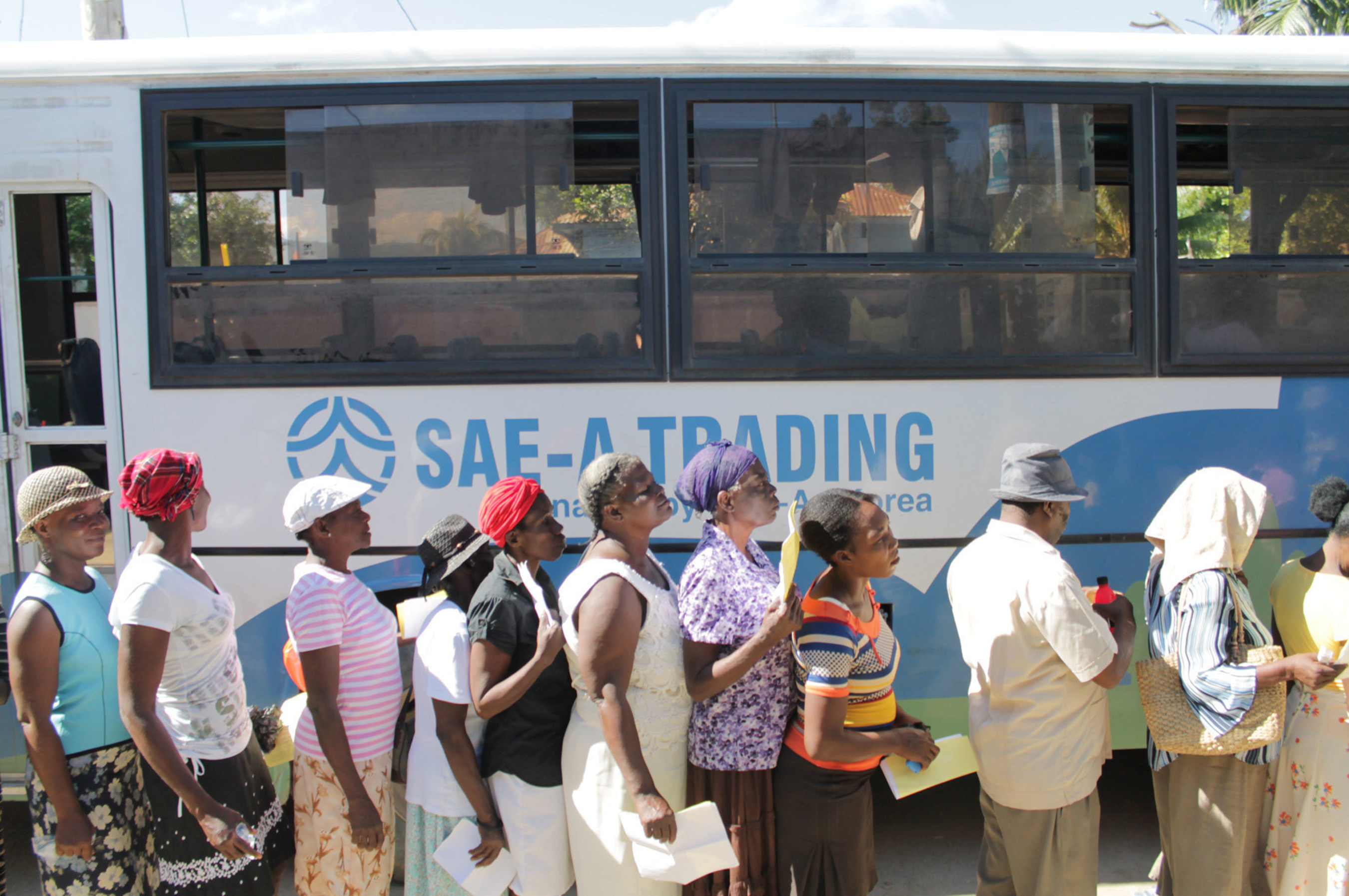 Local residents are standing in line to get on the buses provided by Sae-A to be transported to medical service place.