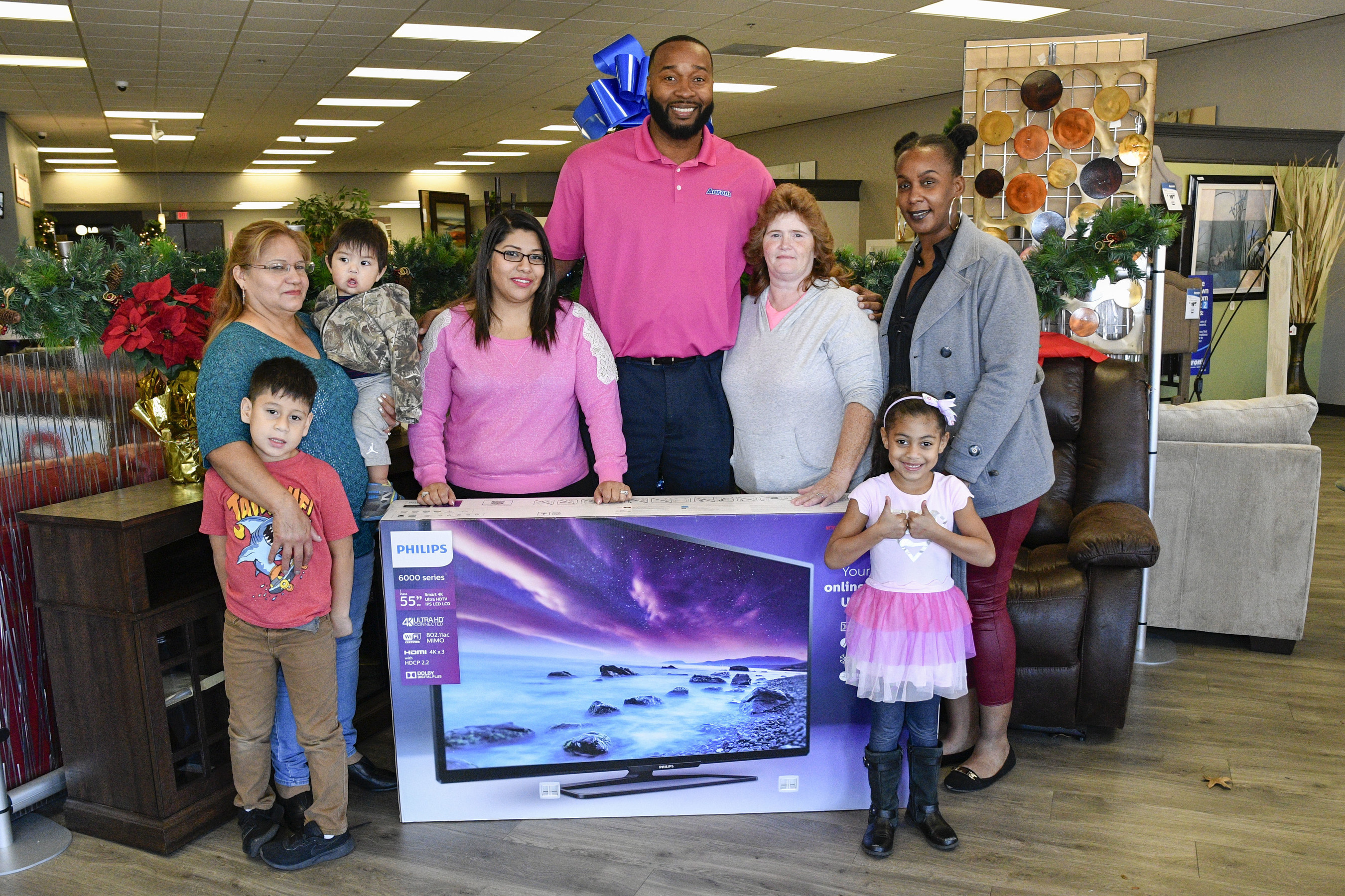 IMAGE DISTRIBUTED FOR AARON'S, INC - Aaron's regional manager Tyrone Washington, center, surprised loyal customers (L - R) Aurora Moreno, her daughter and grandchildren, Melissa Neese and Salina Arnold with free 55" Phillips Smart 4K UHD LED TVs at an Aaron's store on Monday, Nov. 21, 2016, in Atlanta, Ga. Aaron's kicked off a week-long Black Friday celebration today and also surprised loyal customers in Jacksonville, Fla., Memphis, Tenn. and Nashville, Tenn. with free 55" Phillips TVs. (John Amis/AP Images for Aaron's, Inc.)