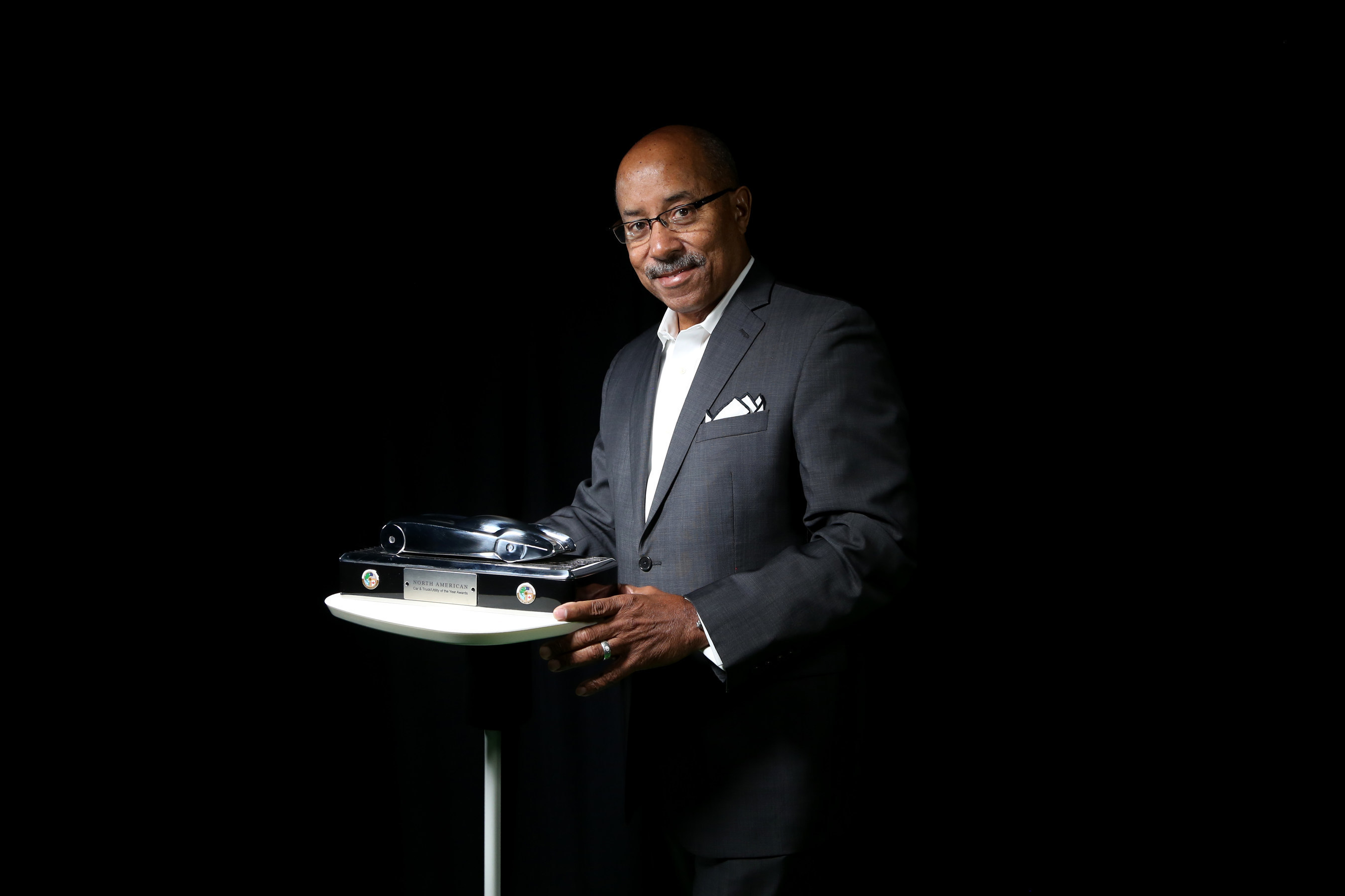 Famed auto designer Ed Welburn with the trophy he created for the North American Car of the Year awards.