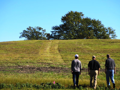 Dramatic ridges and native oak trees highlight the site for Mossy Oak Golf Club in West Point, Mississippi. Renowned golf course architect Gil Hanse (far right) explores the site for the new golf course, which begins development in 2015.