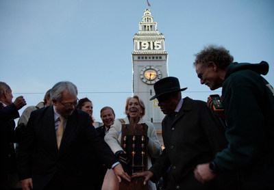 San Francisco Chief of Protocol Charlotte Shultz (center) joins Mayor Ed Lee (left) and former Mayor Willie Brown (right) in "flipping the switch" to turn on the lights to the Ferry Building as it is re-lit to appear as fairgoers would have seen it in 1915. Looking on is steeplejack Jim Phelan (far right) who built the numbers and installed the light bulbs, which will adorn the Ferry Building until December 4.Photo Credit: Michael Tweed.