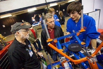 Ric Roberts, left, an engineer at Raytheon Space and Airborne Systems, checks out a student's entry in a robotics competition. Roberts, a longtime supporter of robotics clubs in middle schools and high schools, organizes a Los Angeles-area tournament every year. Standing next to Roberts is Pete Gould, vice president of engineering for Raytheon Space and Airborne Systems.