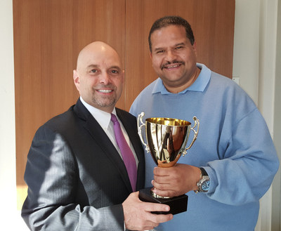 Gene Nicotra, General Manager at New York's Hotel Pennsylvania, awards Ruben Hernandez for his heroic efforts
