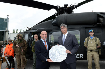 Gerald Klug (left) Austria's Minister of Defence and Sports, and Gerhard Starsich, CEO of the Austrian Mint, show off an enlarged copy of the new silver coin bearing an engraving of an S-70 BLACK HAWK helicopter. A ceremony to unveil the coin took place May 6 at the Brumowski Air Base in Langenlebarn near Vienna. The coin was issued to commemorate the 60th anniversary of the formation of the Austrian Armed Forces.  Austrian Mint photo.