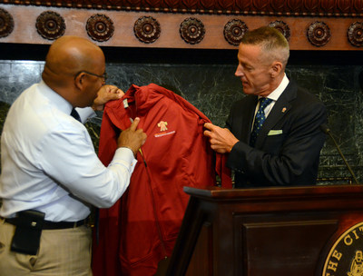 Eric J. Foss, Aramark Chairman, President and Chief Executive Officer (right), presents a commemorative World Meeting of Families - Philadelphia 2015 jacket to Philadelphia Mayor, Michael A. Nutter (left), at a press conference announcing Aramark as the official retail vendor of event merchandise for the World Meeting of Families Congress and Papal Visit. (Credit World Meeting of Families/Sabina Pierce)